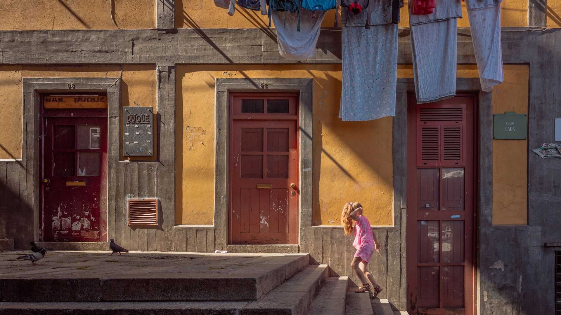 person walking on stairs beside brown door house