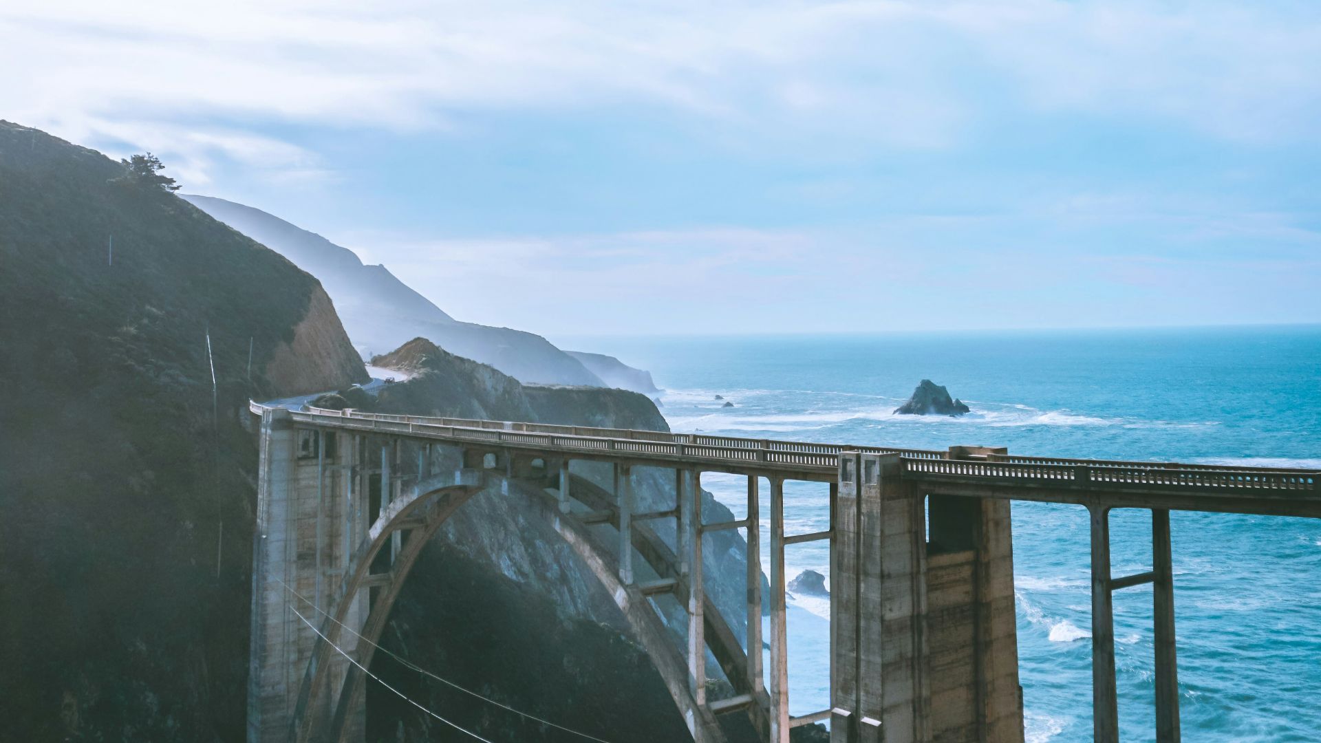gray concrete bridge across the mountain
