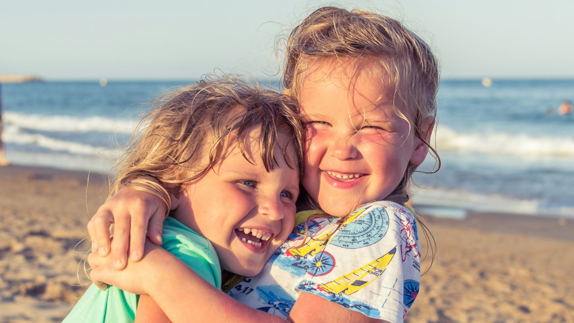 girl in white blue and green floral dress on beach during daytime