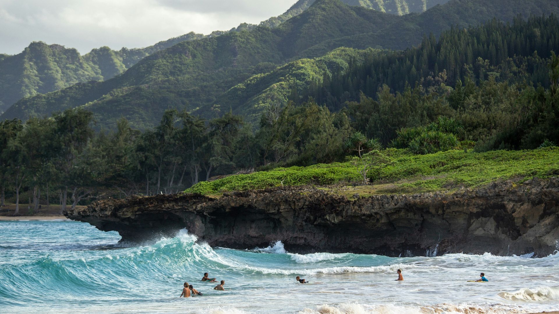 people swimming near shore with waves during daytime