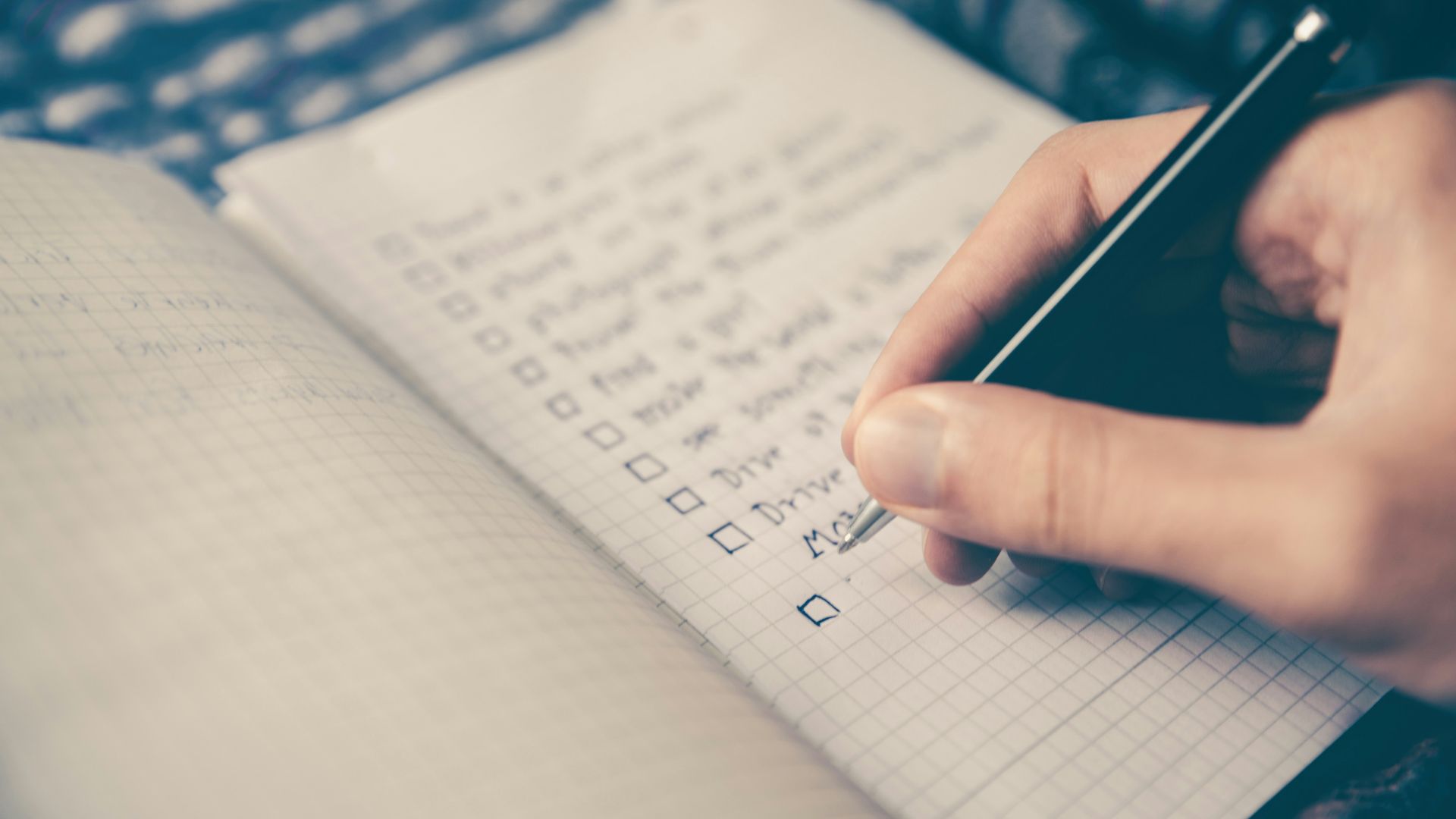 person writing bucket list on book