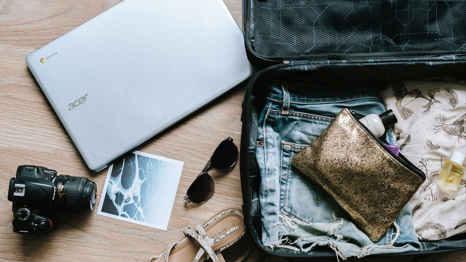 black DSLR camera near sunglasses and bag