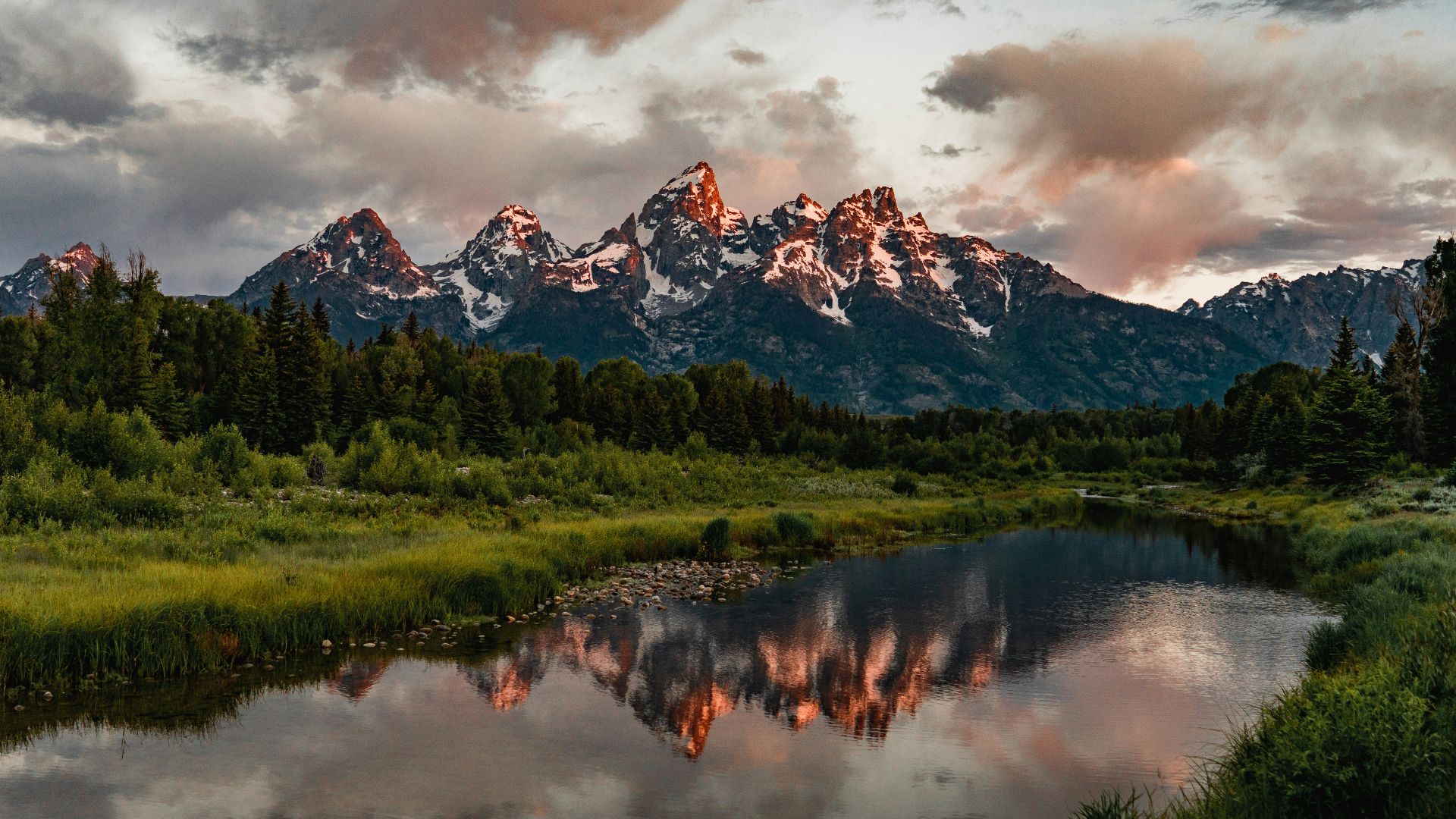 green trees near lake and snow covered mountain during daytime