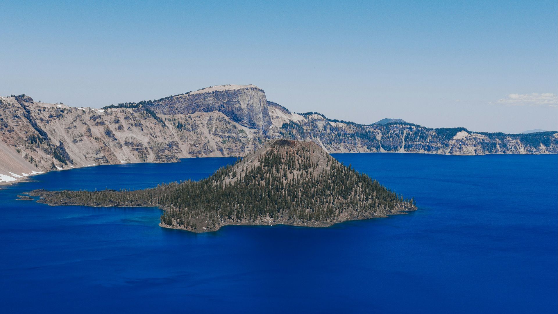 blue sea near mountain under blue sky during daytime