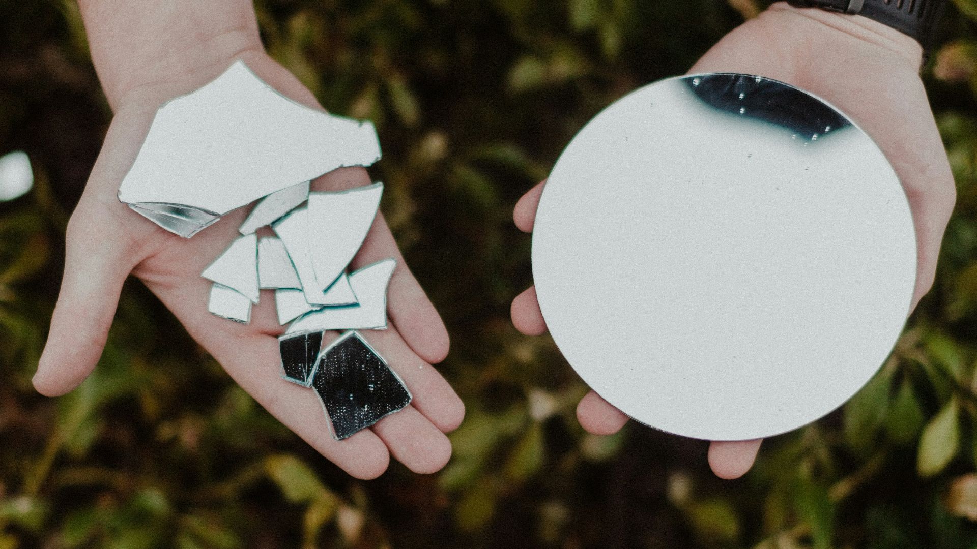 person holding round mirror