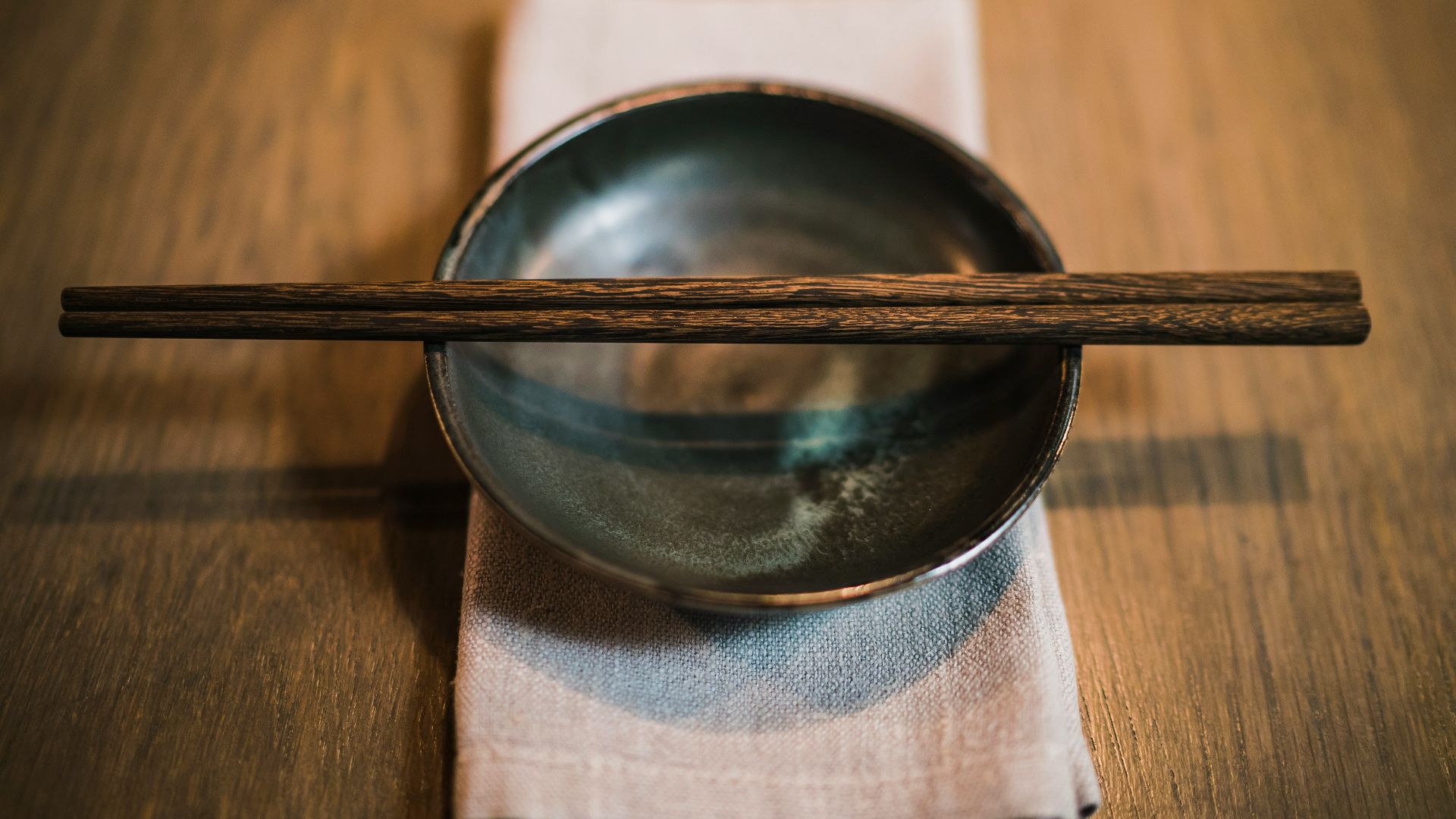 pair of brown chopsticks on round ceramic bowl
