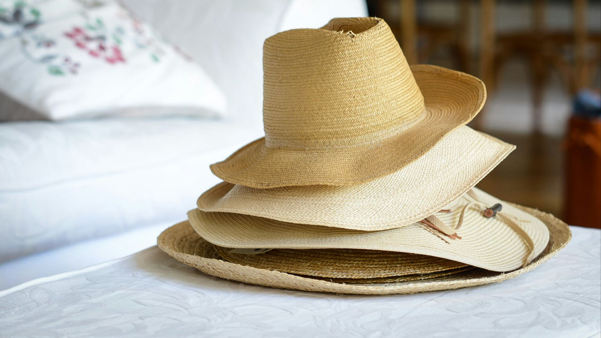 five brown straw nesting hats on white textile