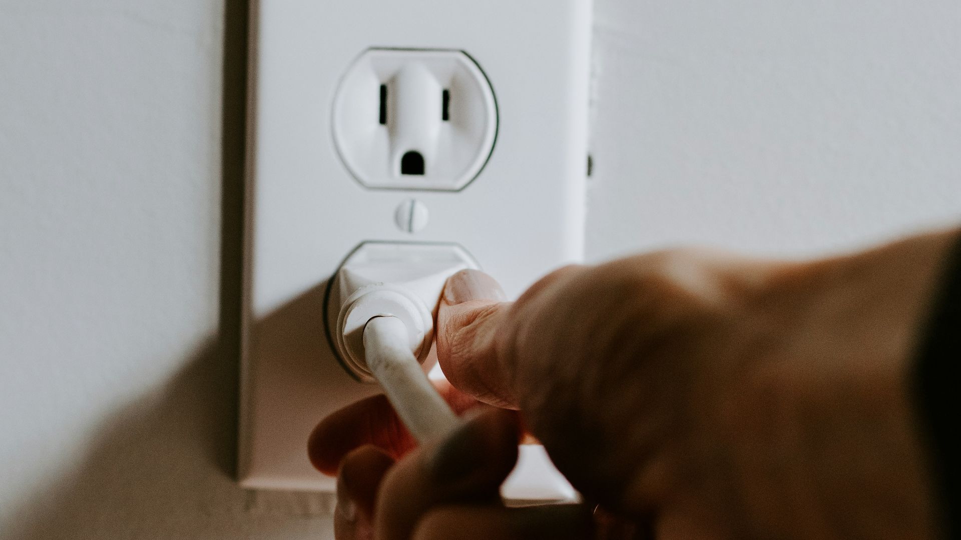 person holding white electric plug