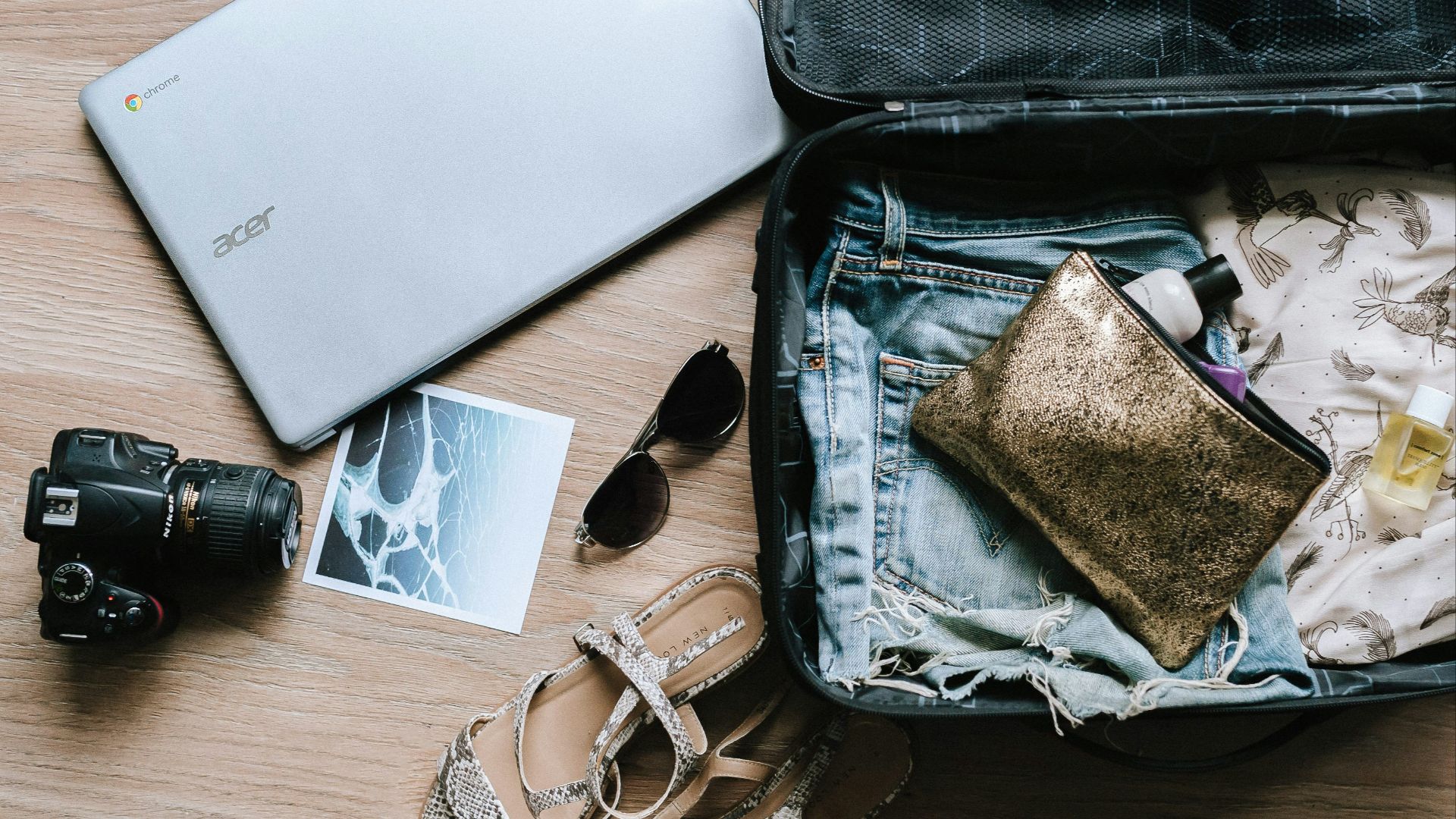 black DSLR camera near sunglasses and bag