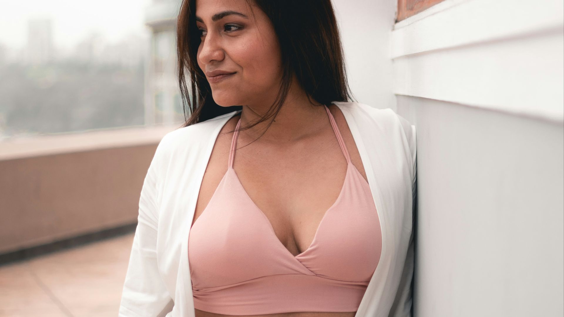 woman waering pink bra and white cardigan