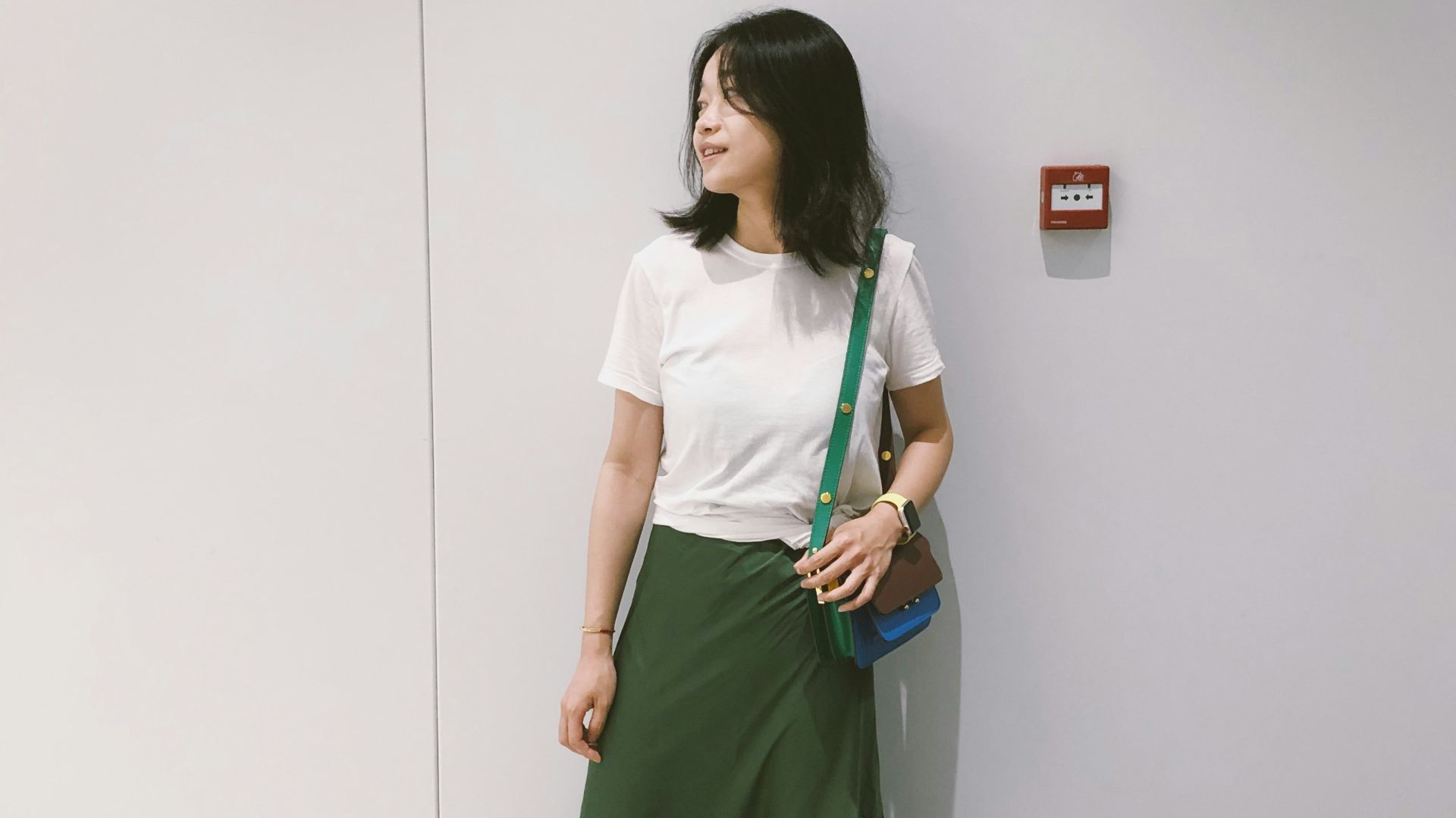 woman looking at her right standing against the wall