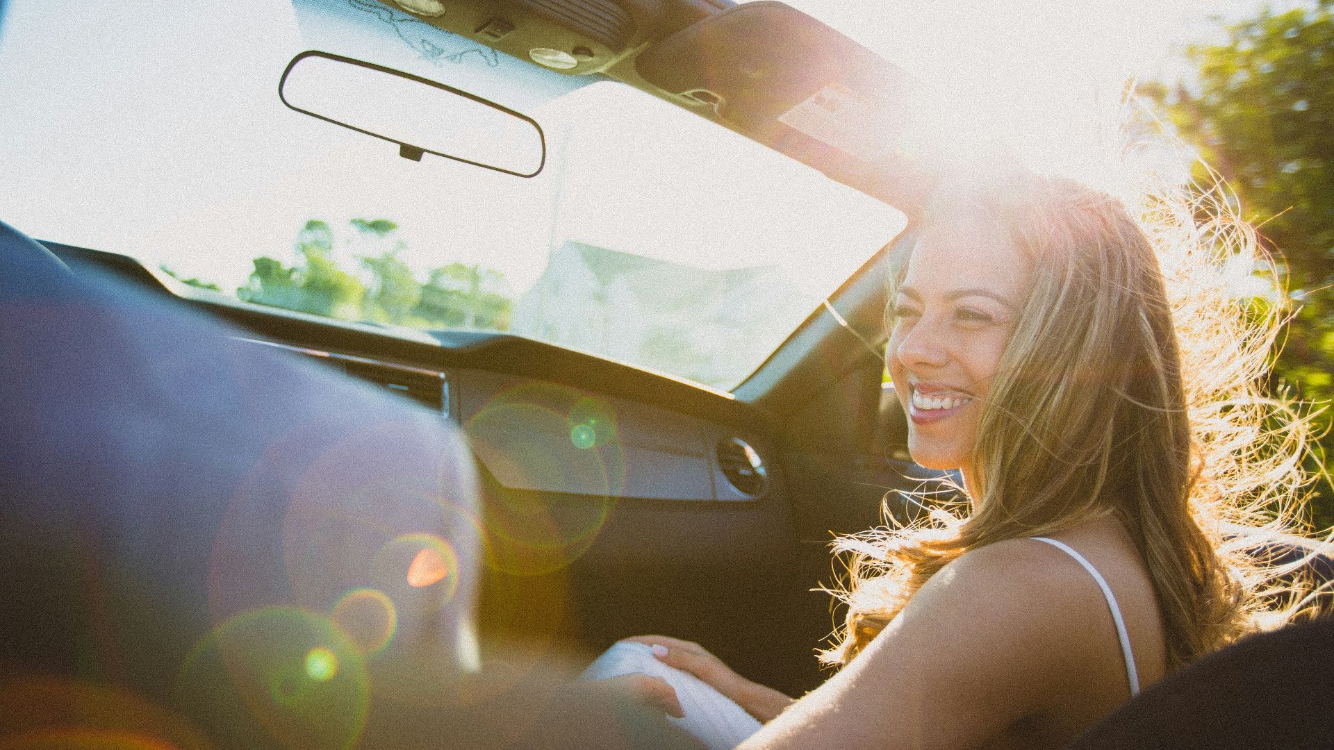 smiling woman sitting inside the vehicle at daytime