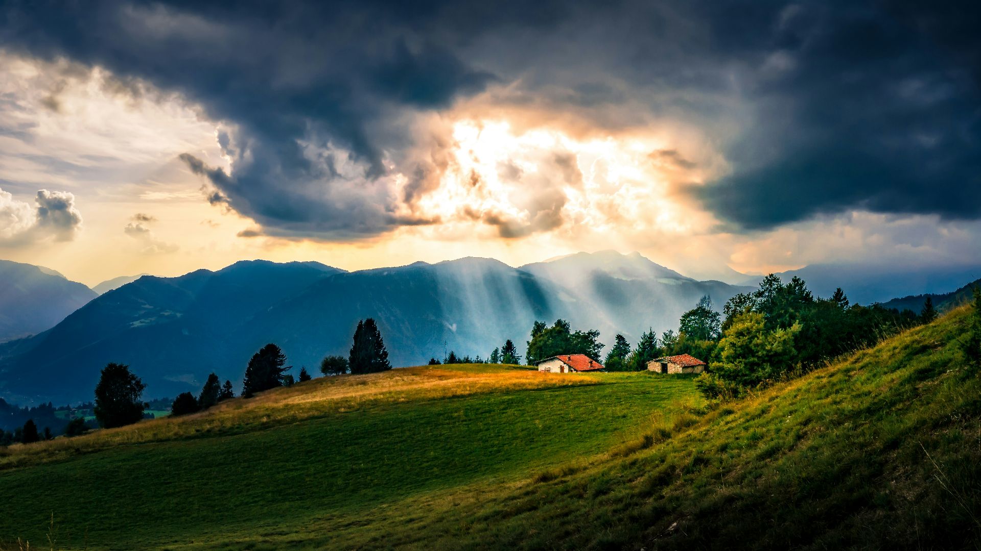 the sun shines through the clouds over a grassy hill