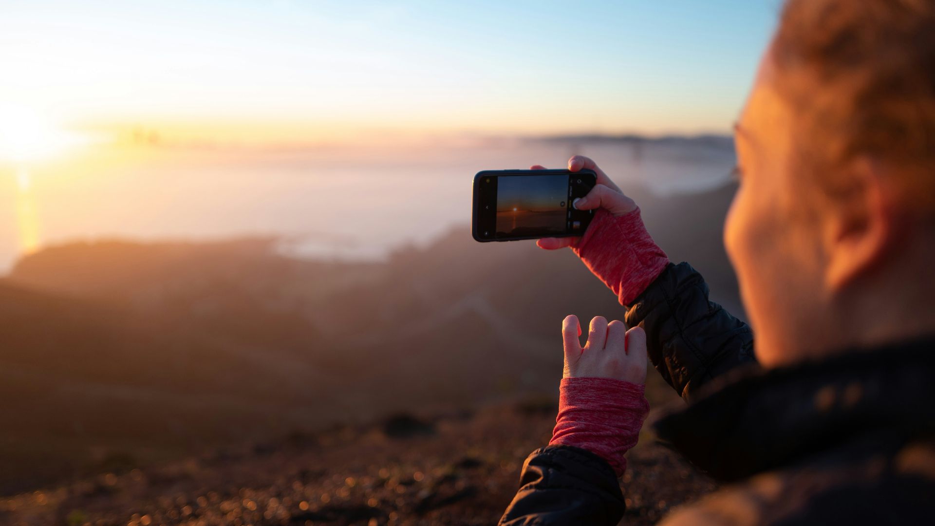 person holding black smartphone taking photo of brown mountain during daytime