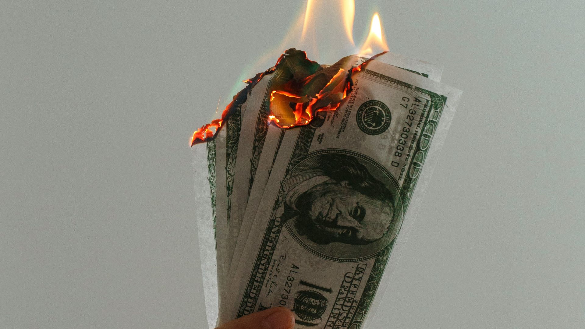 time lapse photography of several burning US dollar banknotes