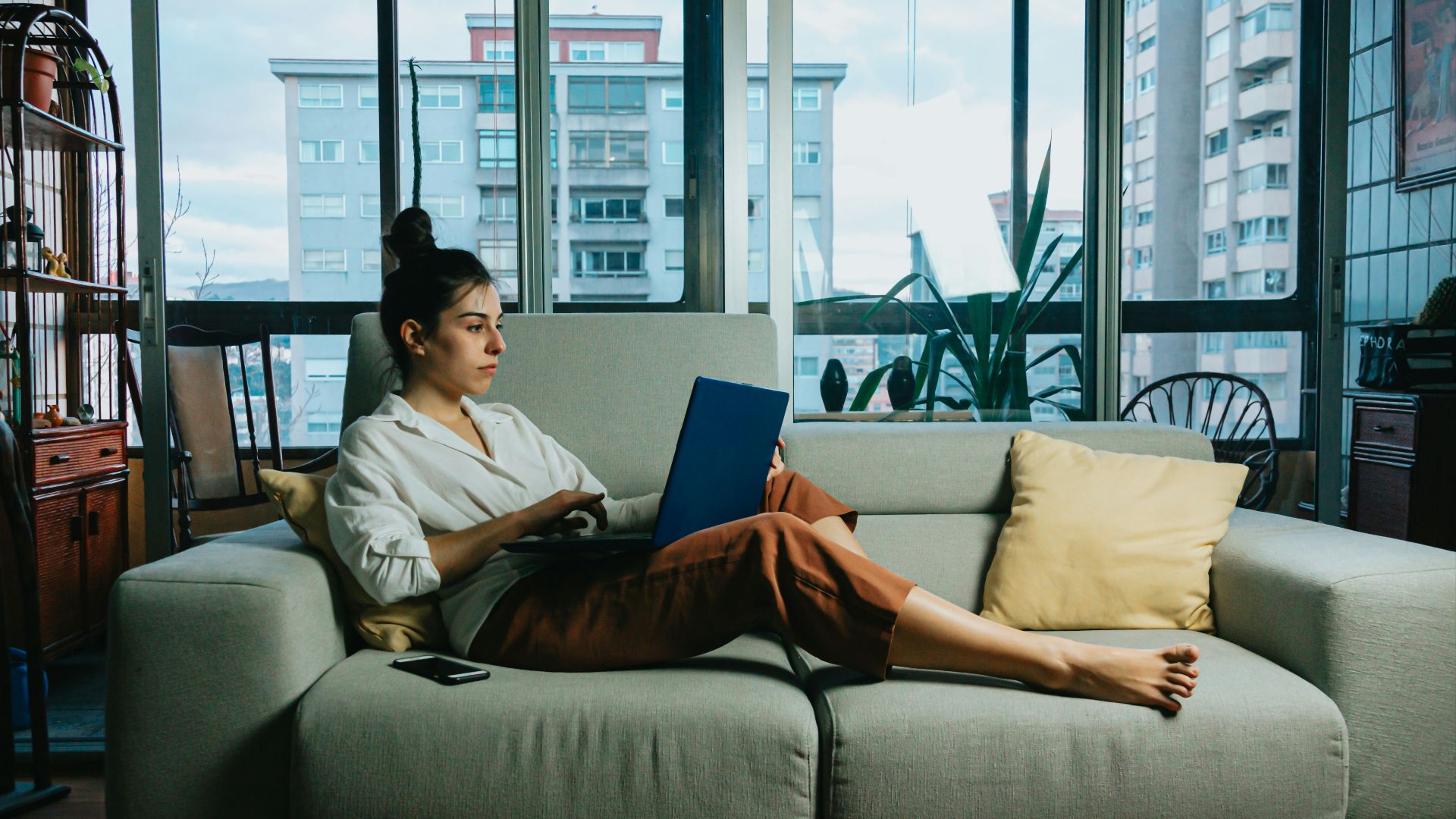 woman in white long sleeve shirt sitting on white couch