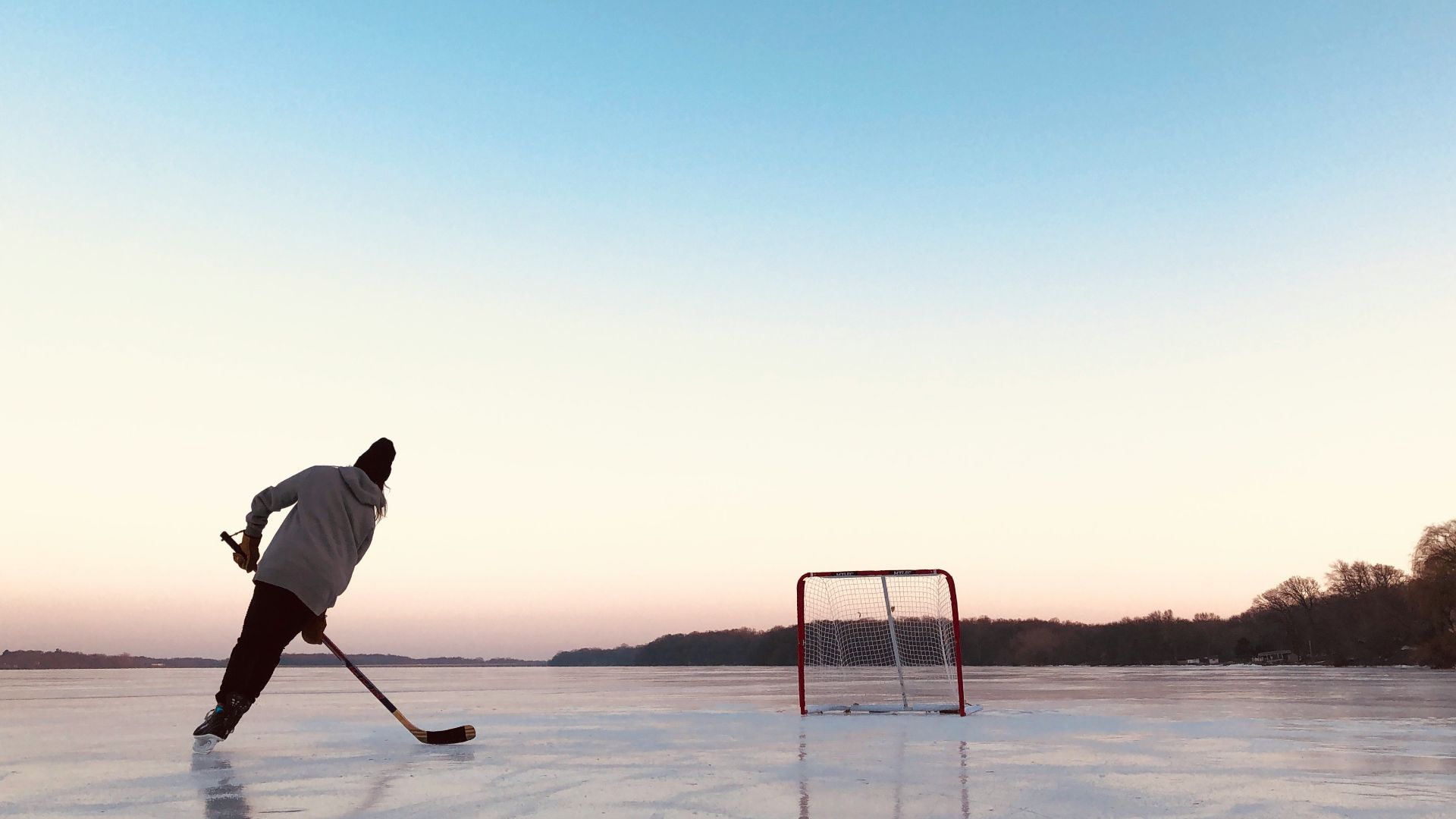 man in white shirt and black pants holding white stick standing on snow covered ground during