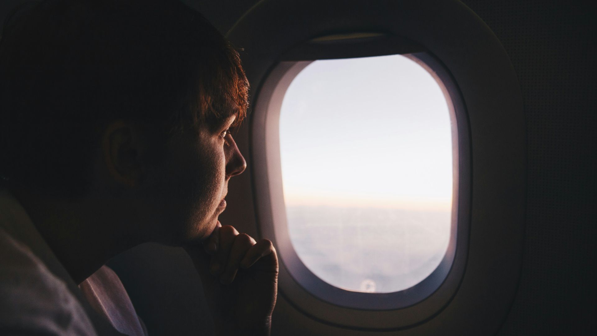man looking at window inside plane