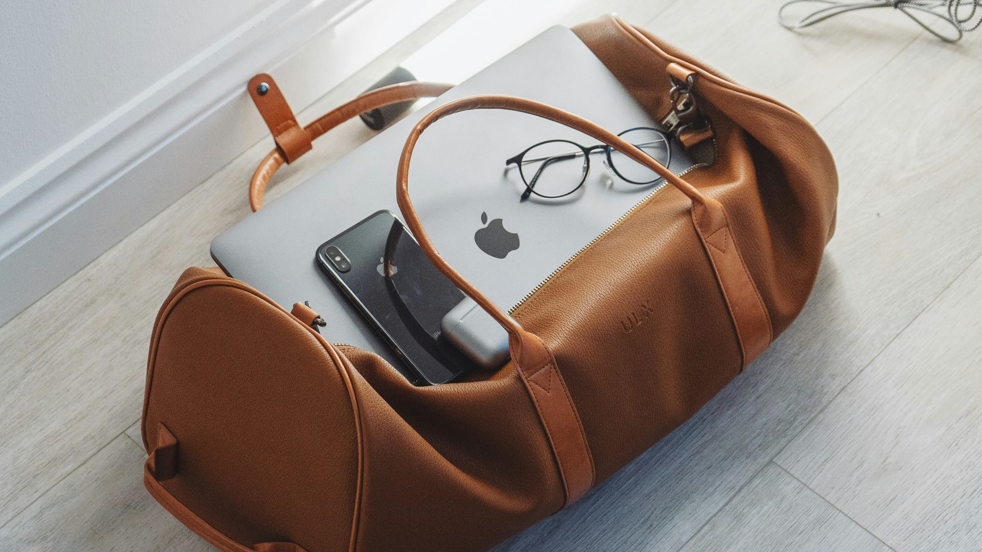 silver MacBook in duffel bag