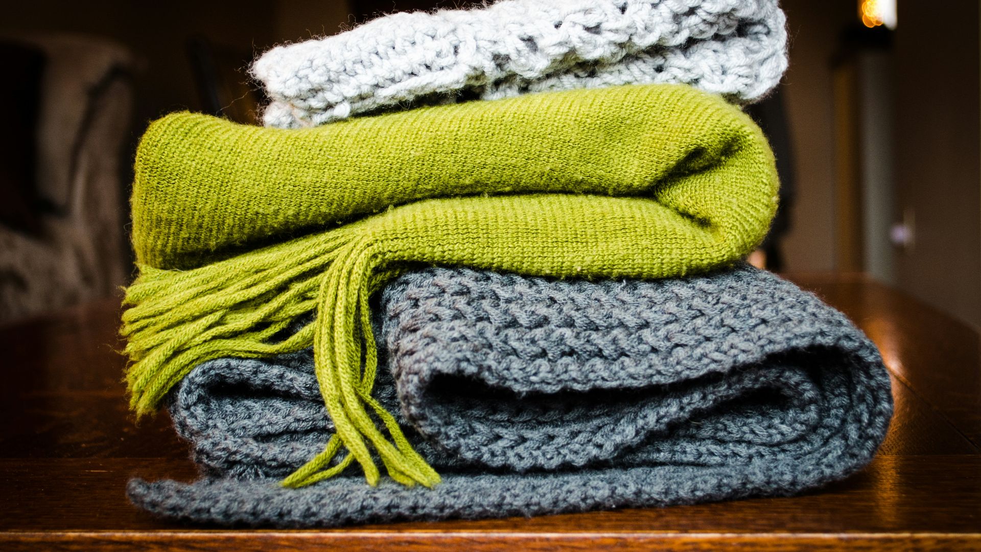 three gray, green, and white scarf on top of table