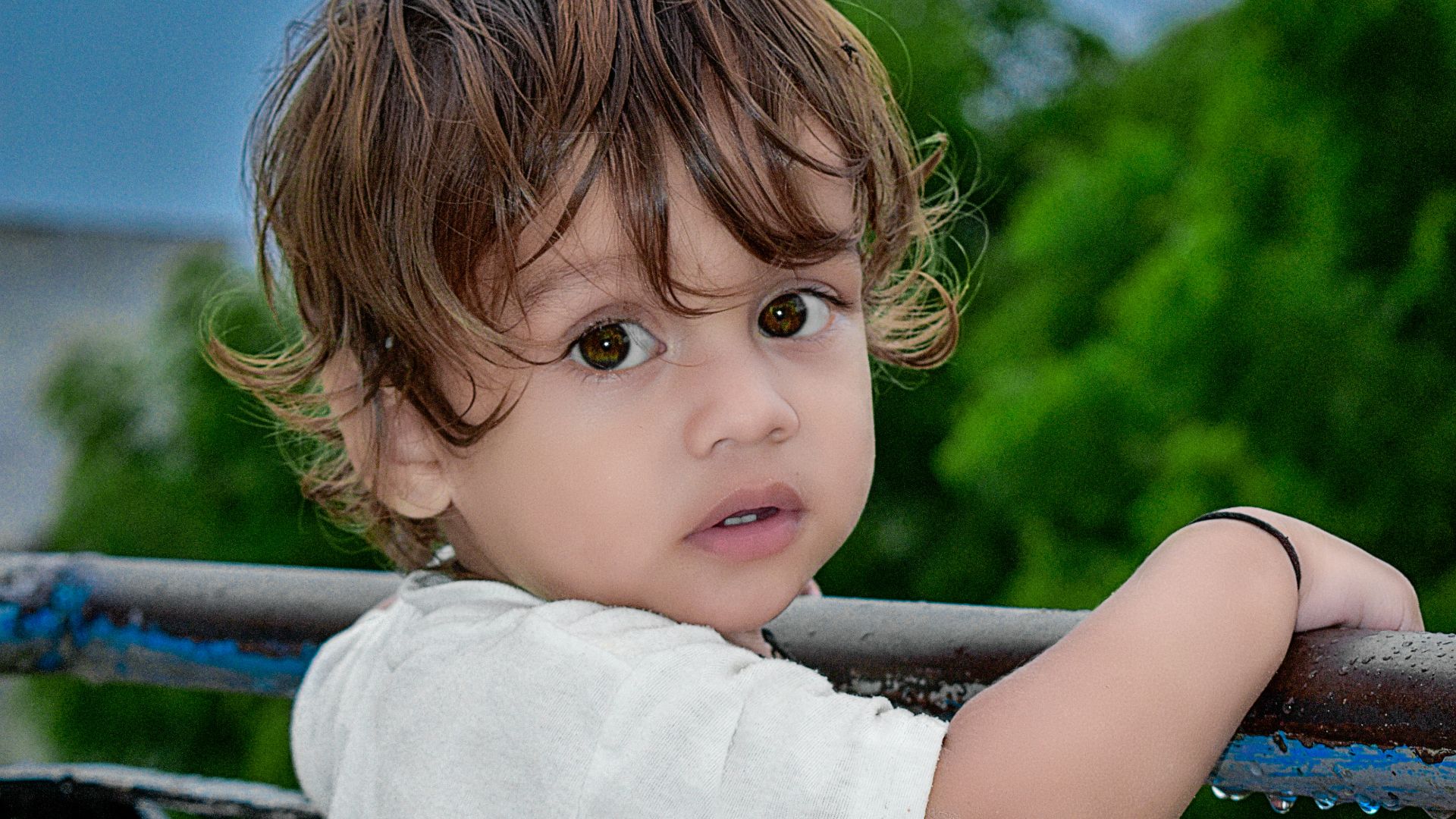 girl in white shirt standing on black metal railings during daytime