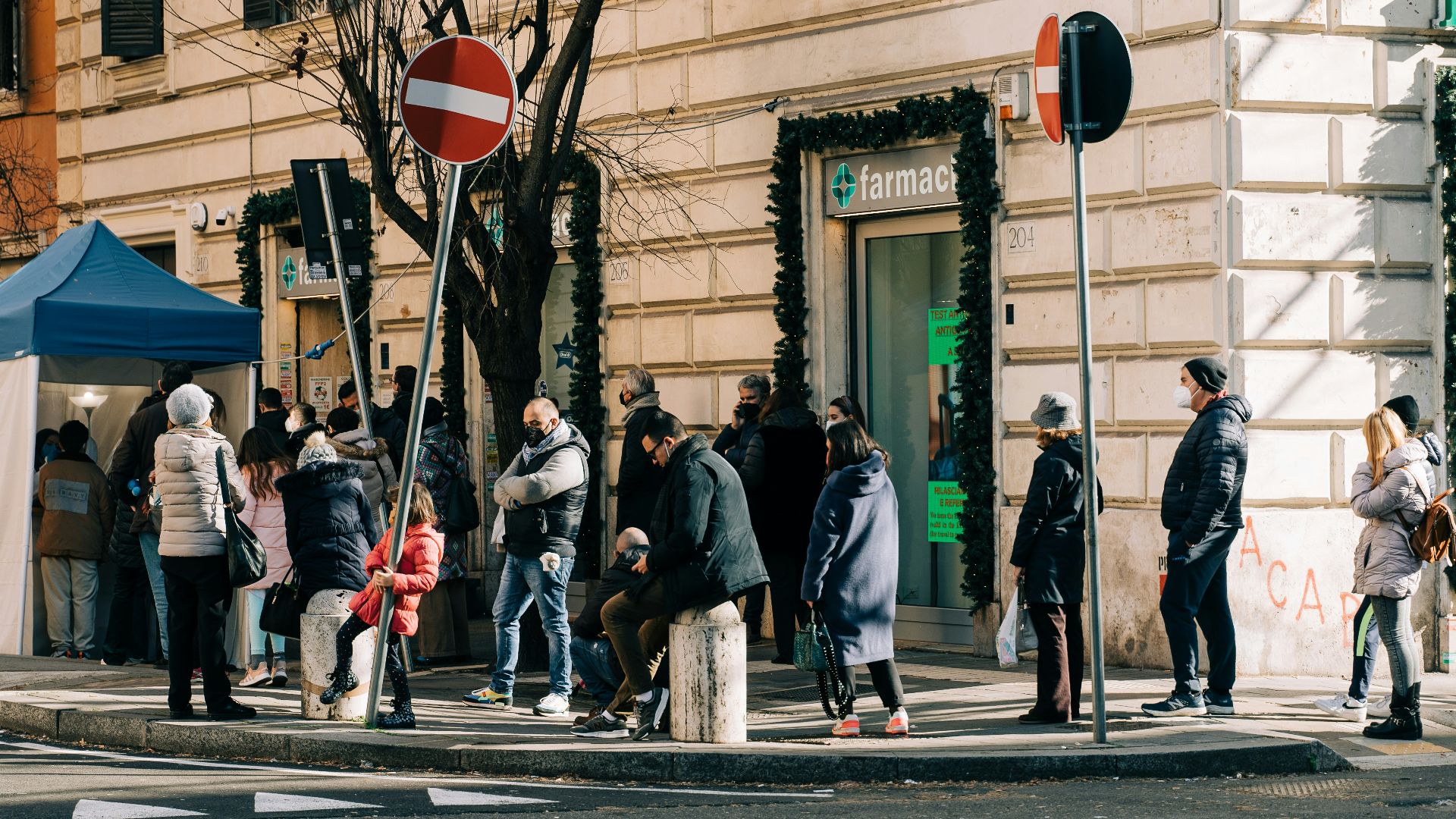 a group of people standing on the side of a street