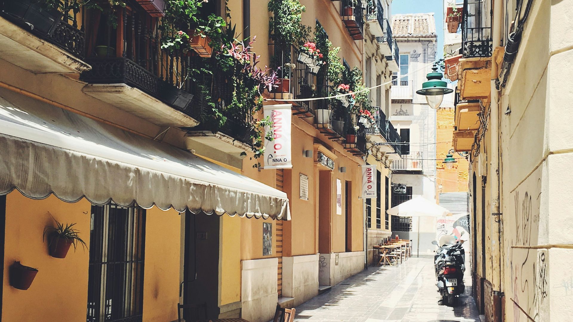 empty seats and tables in between buildings during daytime