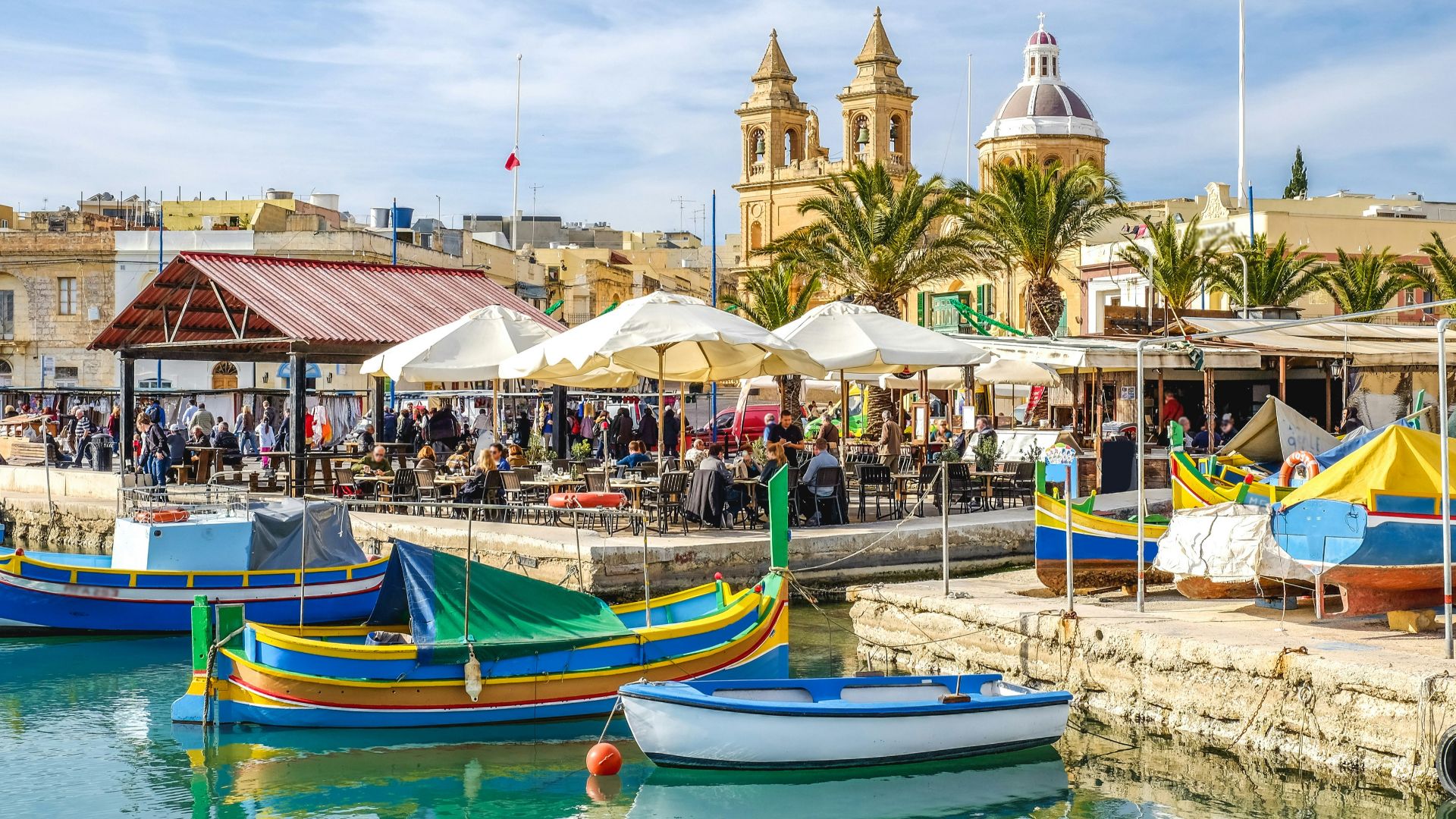 blue and yellow boat on water near brown concrete building during daytime