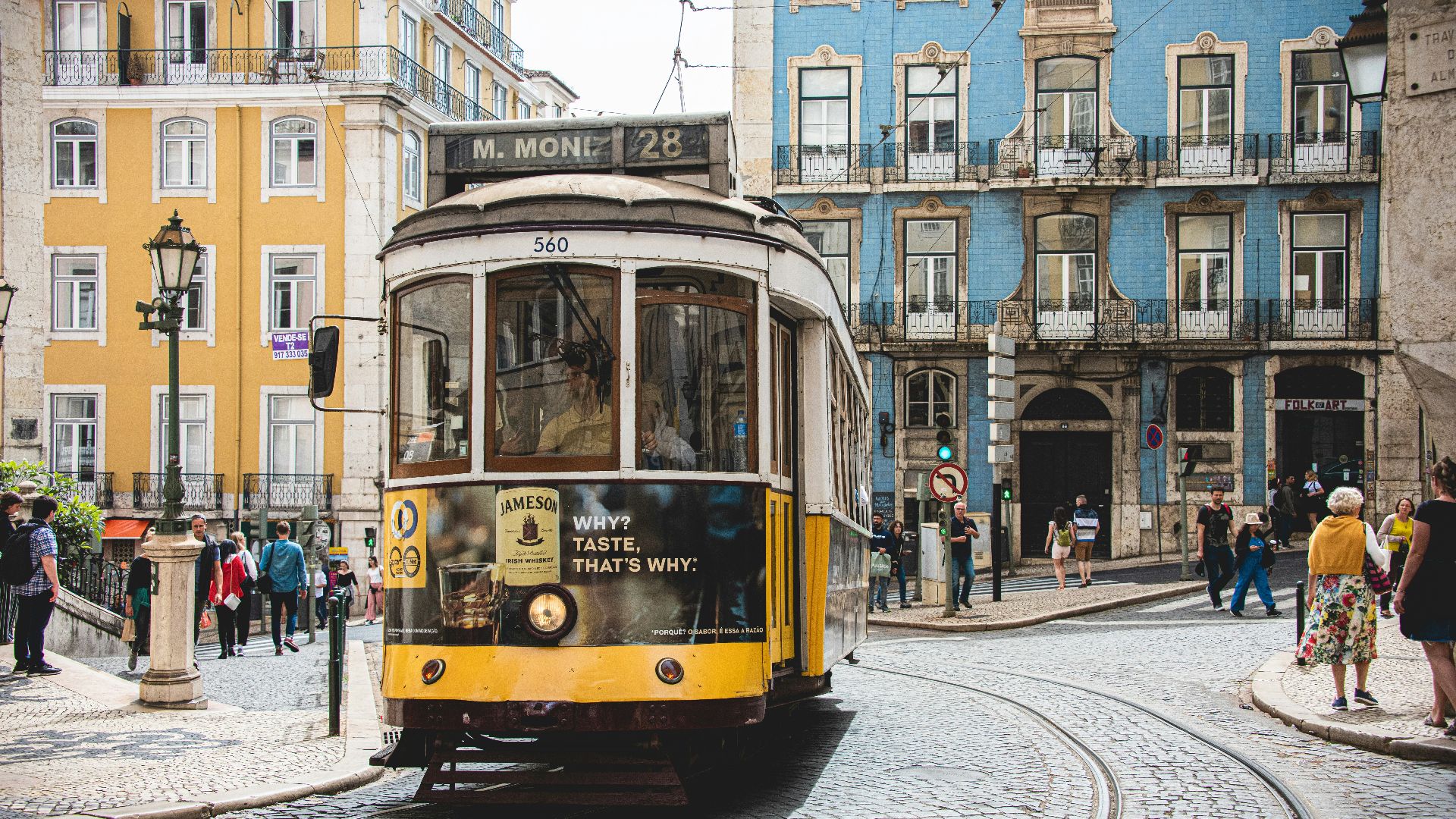 yellow and white tram on road near white concrete building during daytime