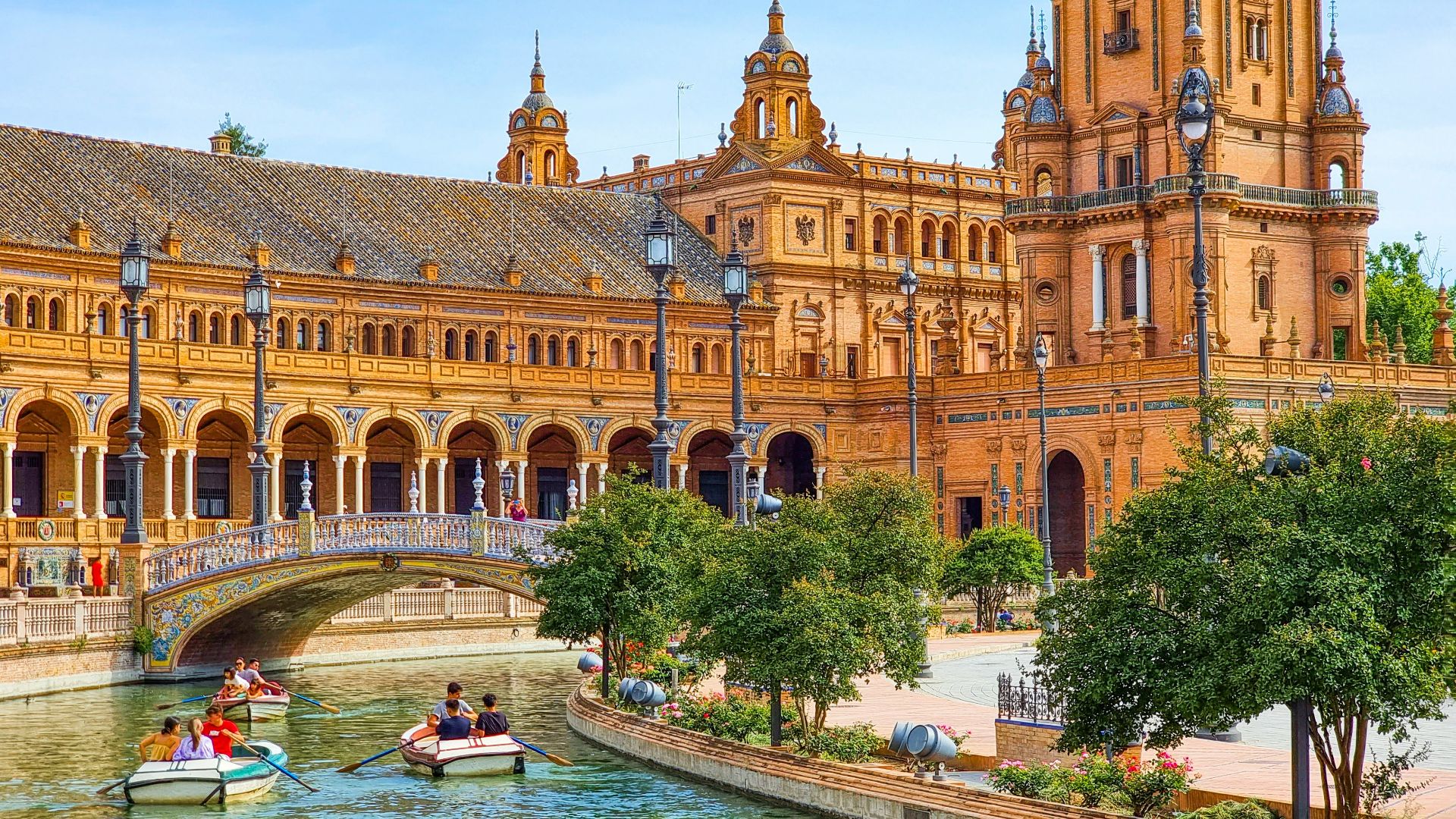 a group of people in a boat in a river in front of a large building