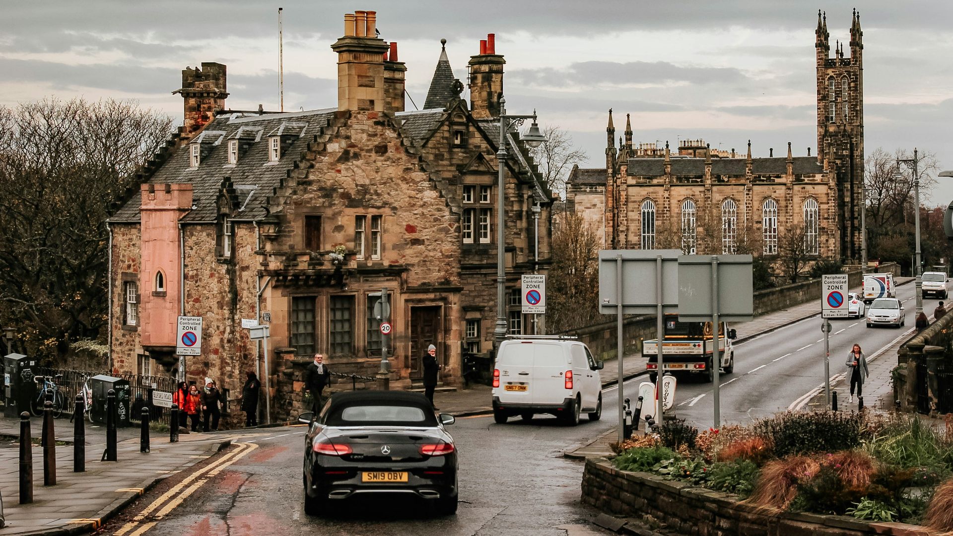 black car parked beside brown concrete building during daytime