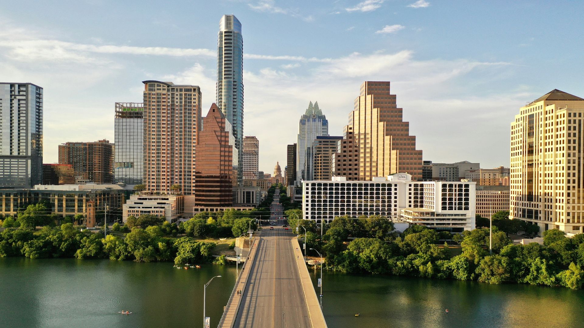 man in black jacket walking on bridge near body of water during daytime
