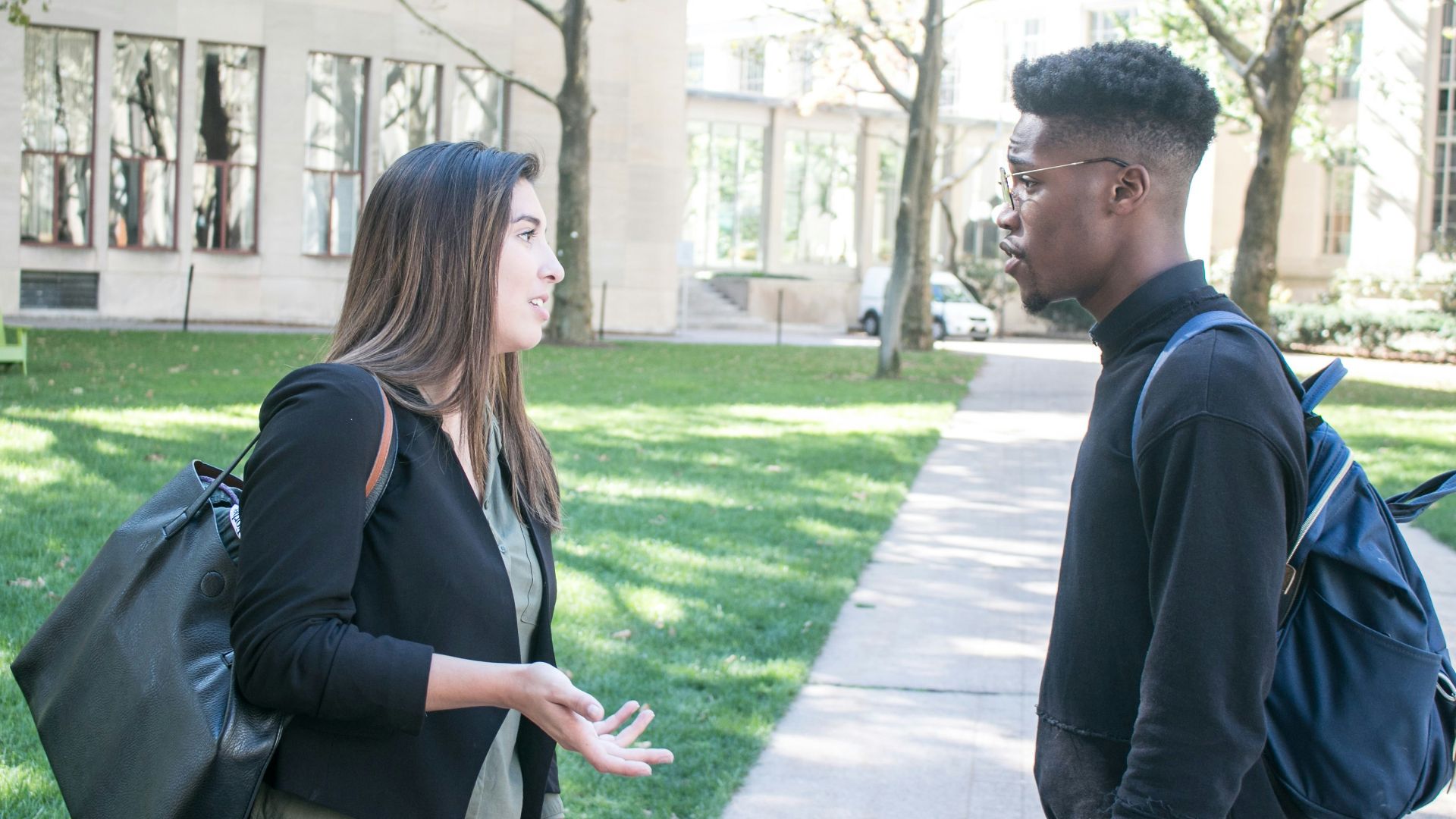 a man standing next to a woman on a sidewalk