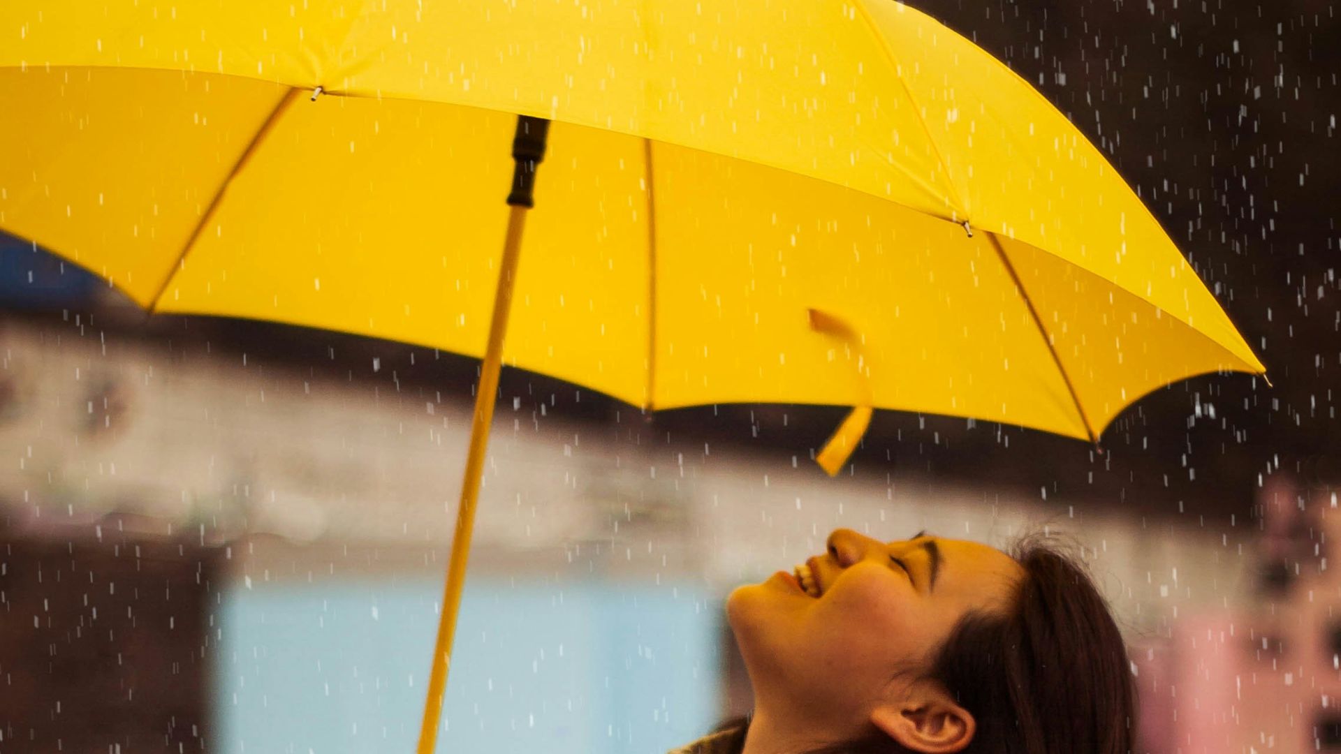 woman in gray jacket holding yellow umbrella