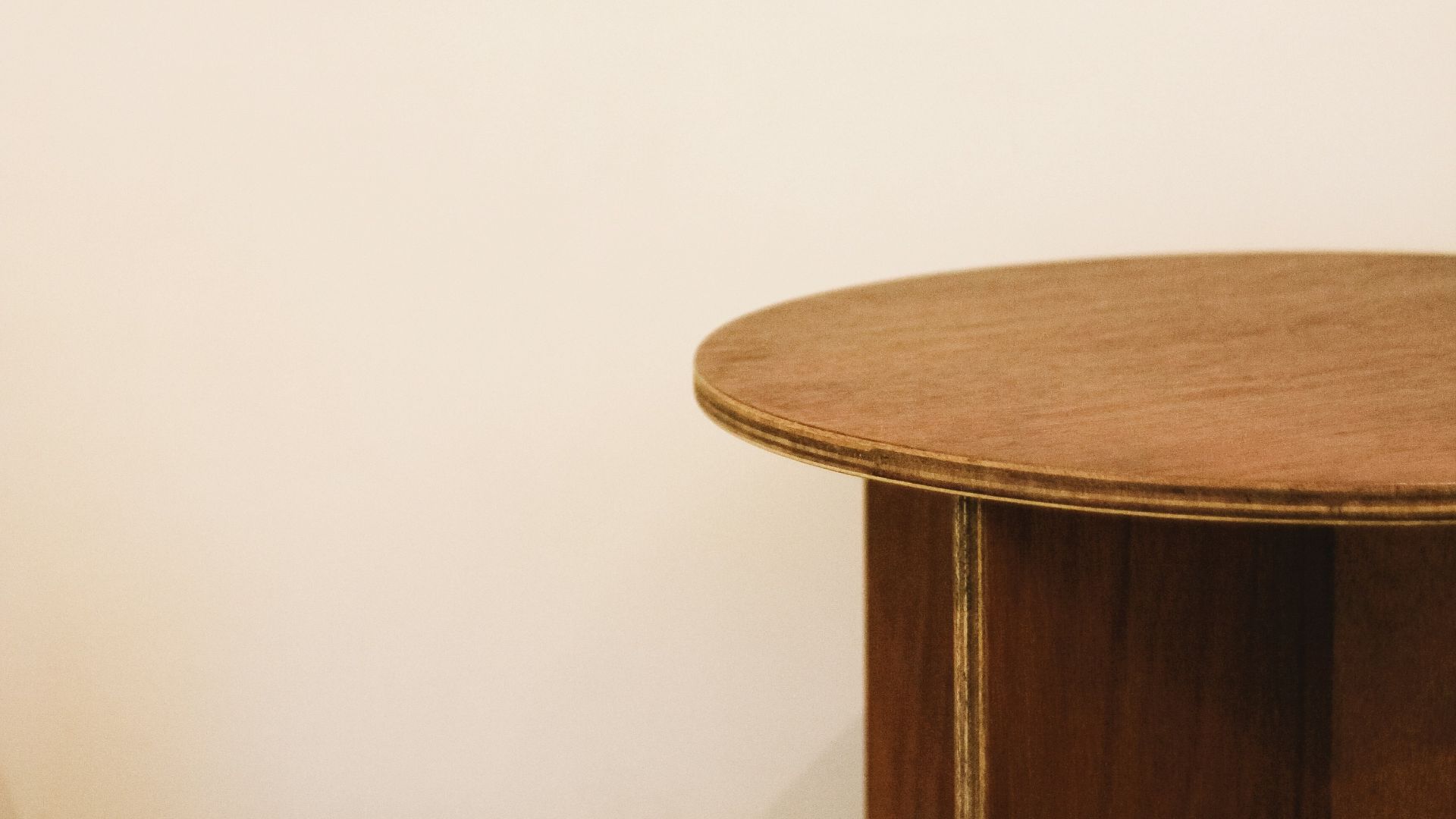 brown wooden end table beside white wall