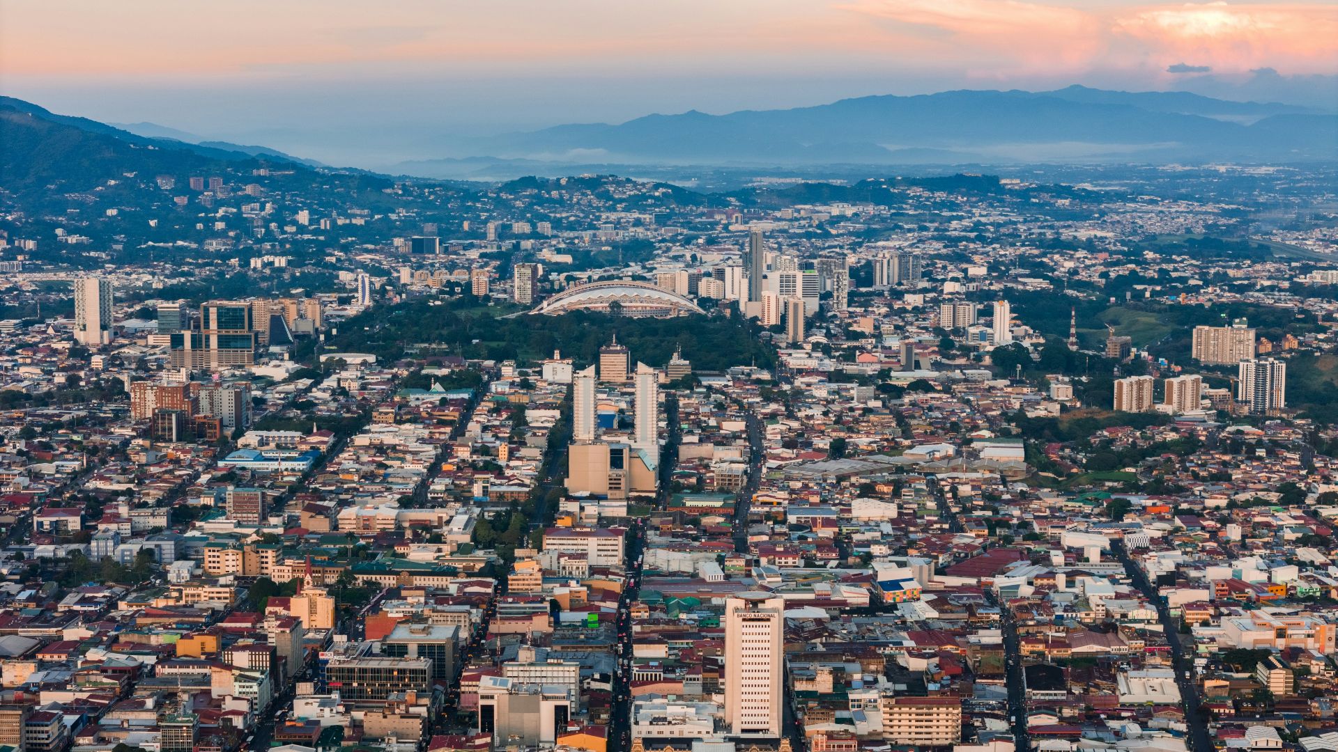 an aerial view of a city with mountains in the background