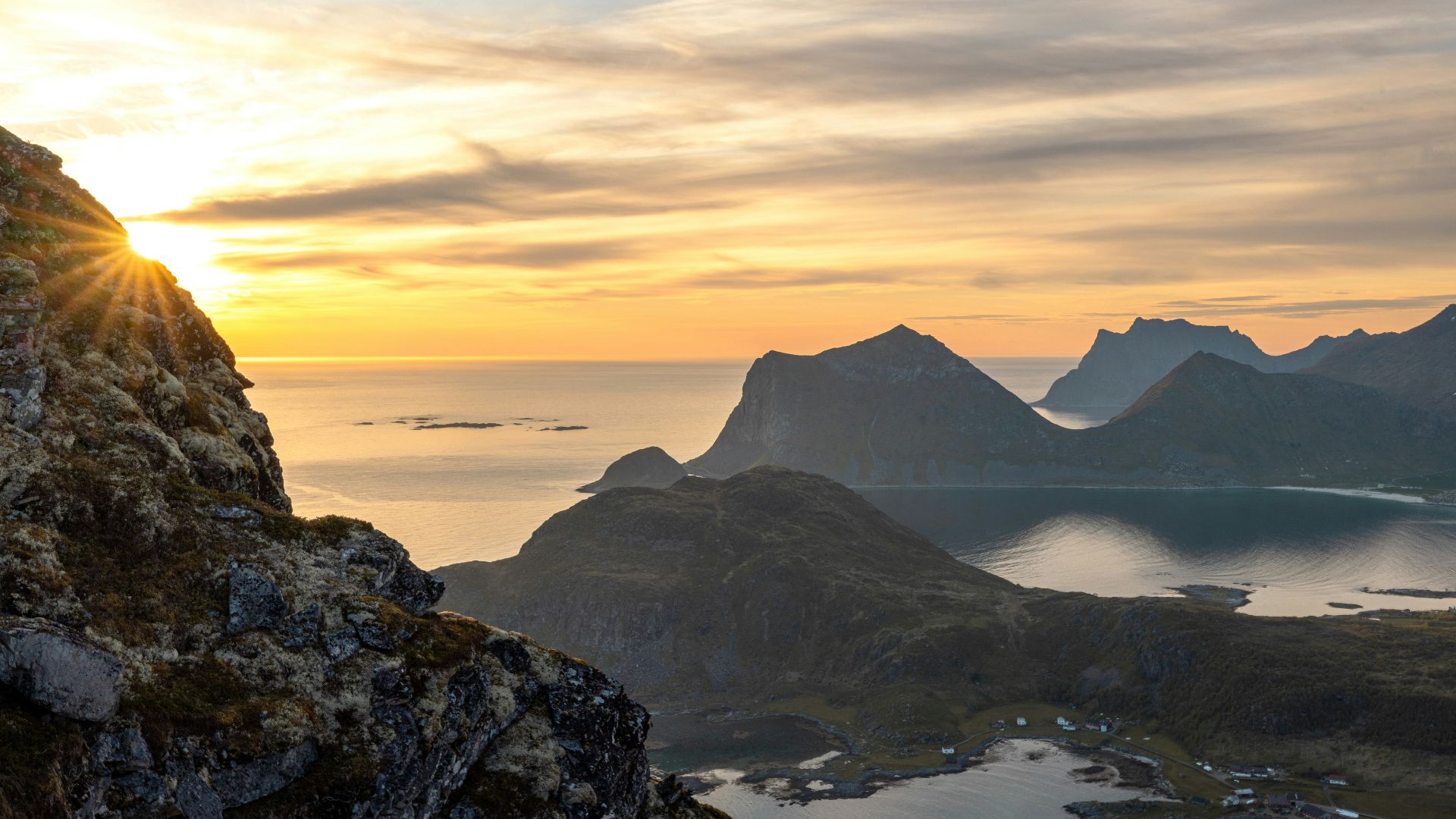 a bird sitting on a rock overlooking a lake and mountains