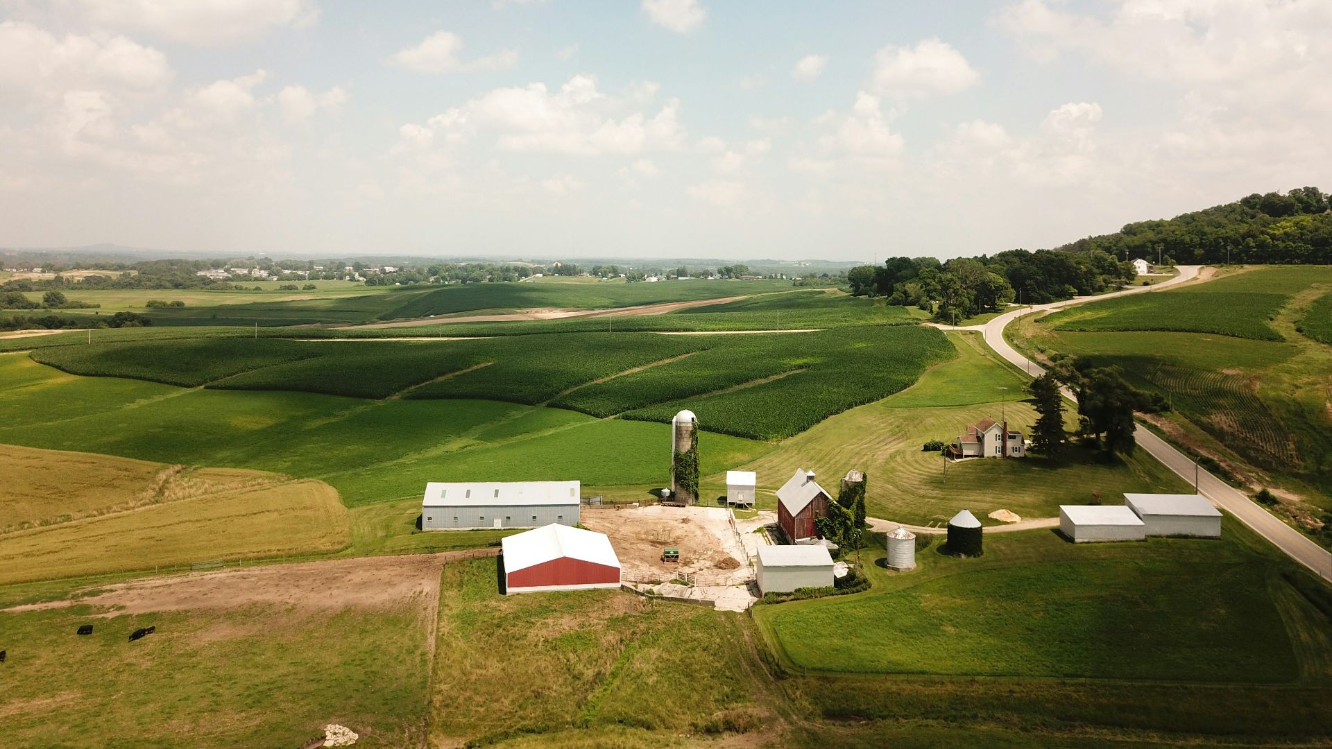 bird eye view photography of white and brown house surrounded by green grass field