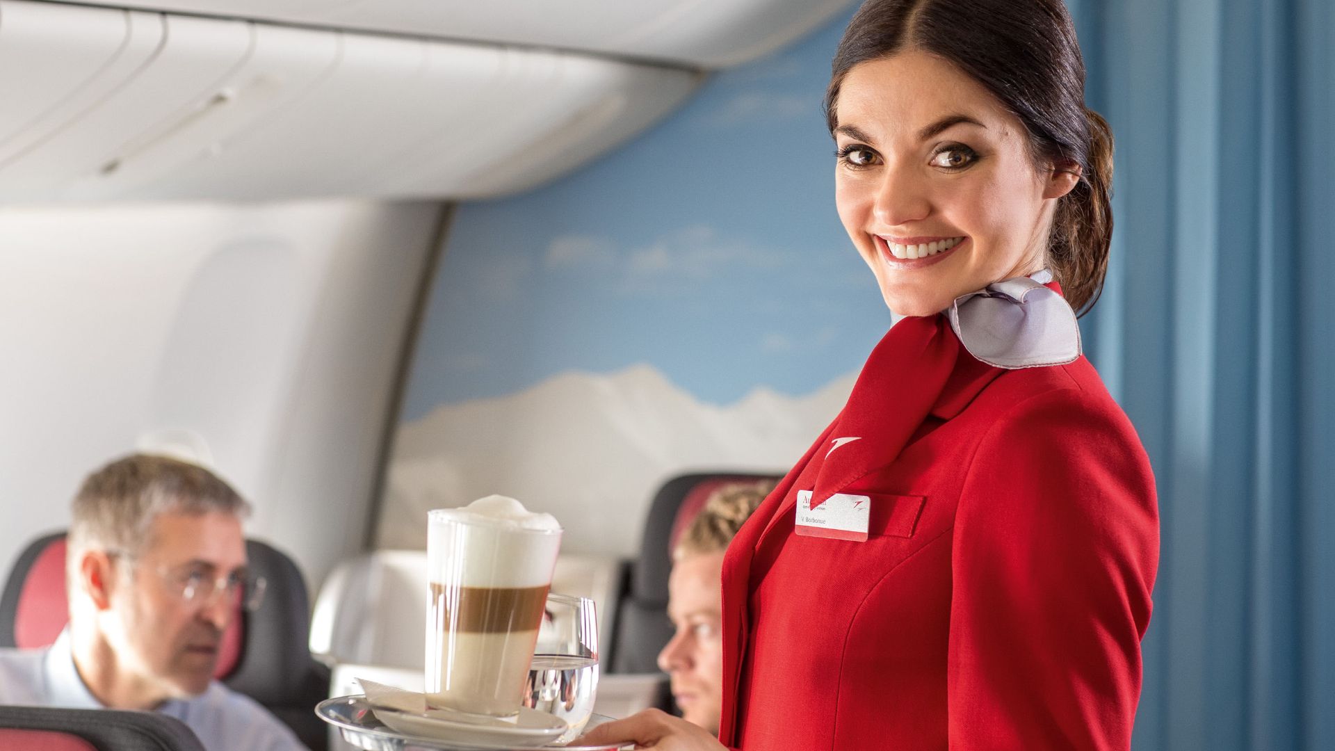 File:An Austrian Airlines flight attendant serving refreshments to passengers.jpg