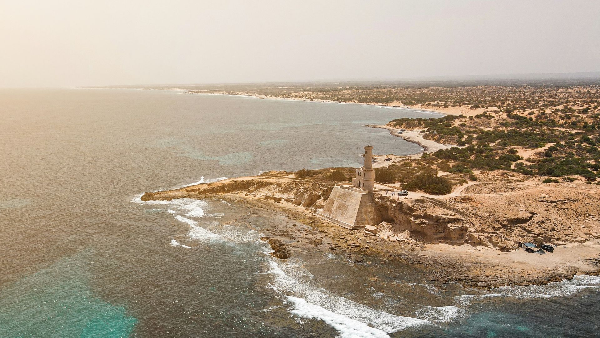 an aerial view of an island with a lighthouse