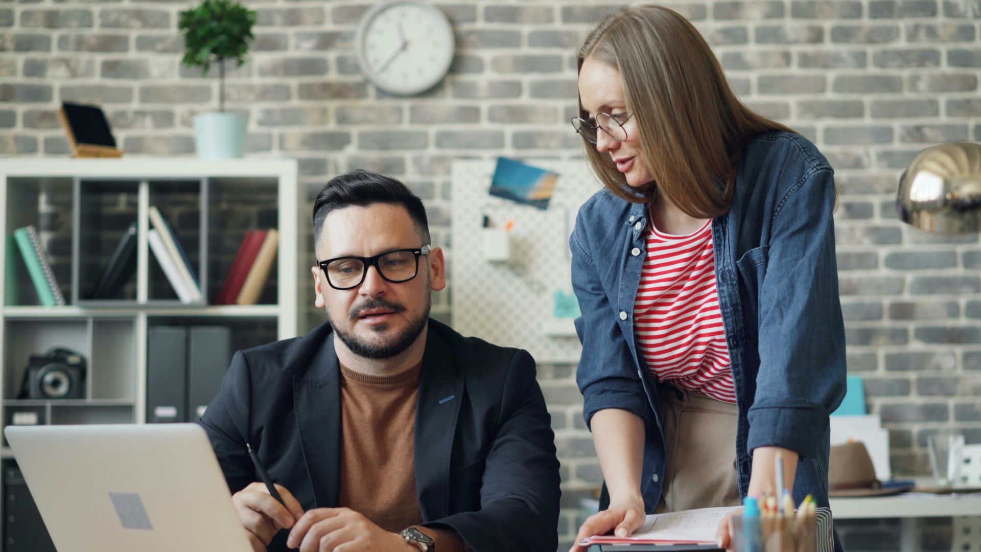 a man and a woman looking at a laptop