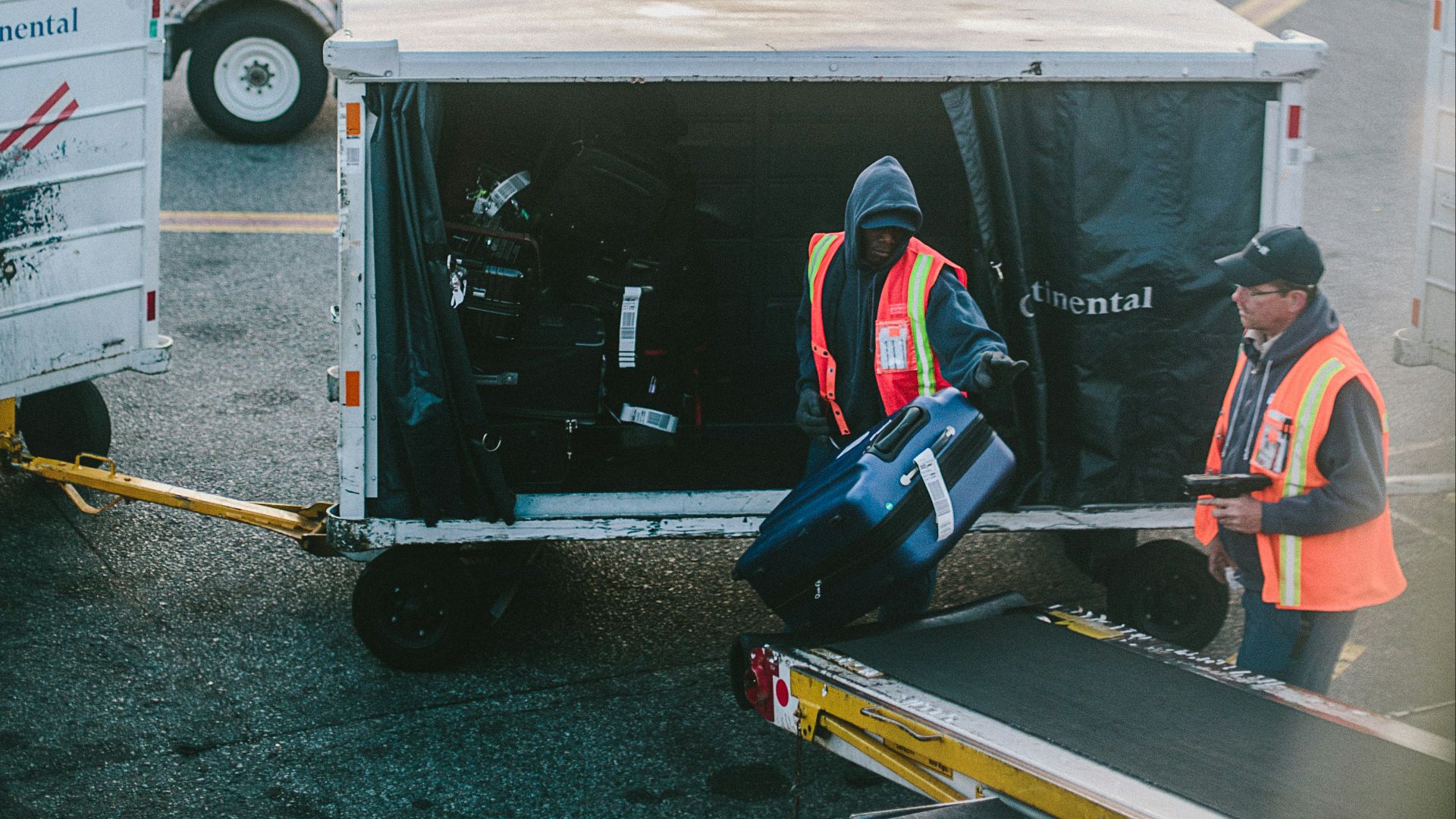 two men holding luggage on airport