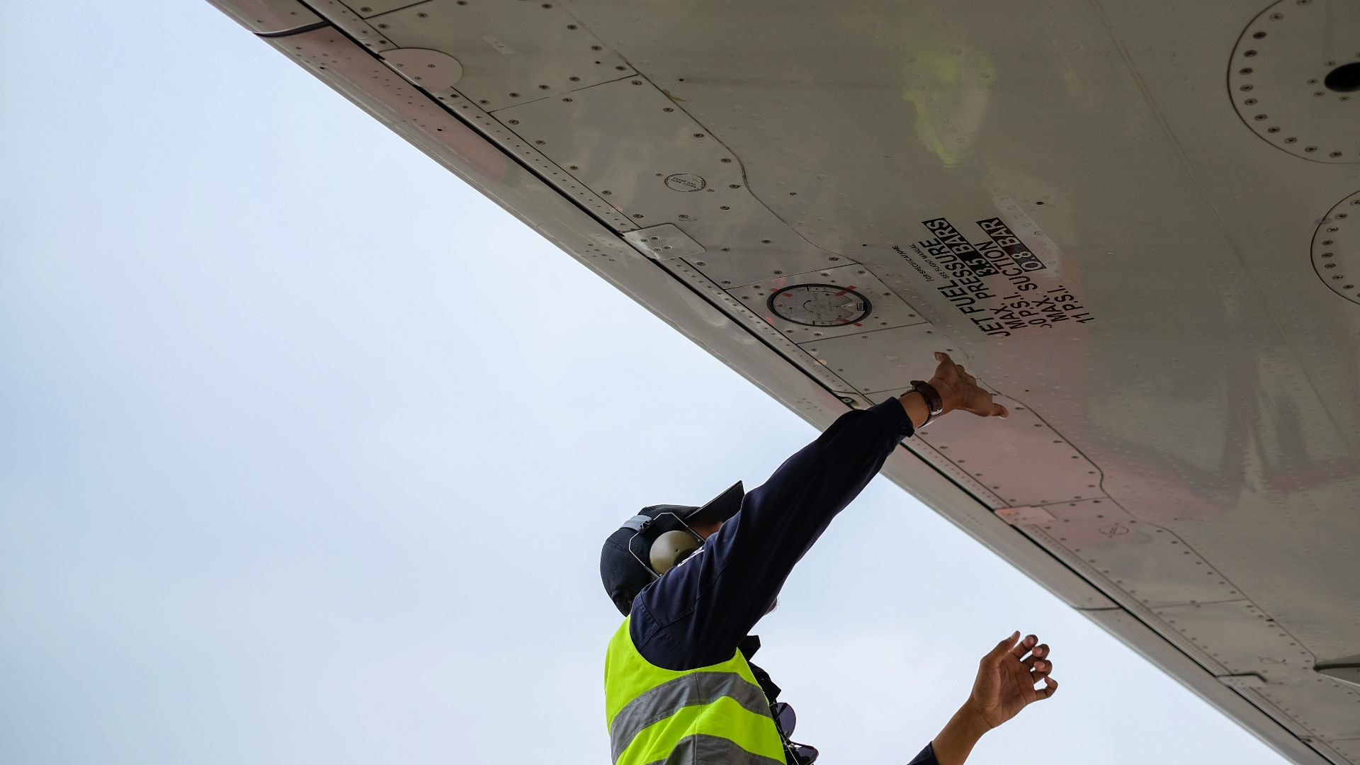 man in green safety vest standing under white structure