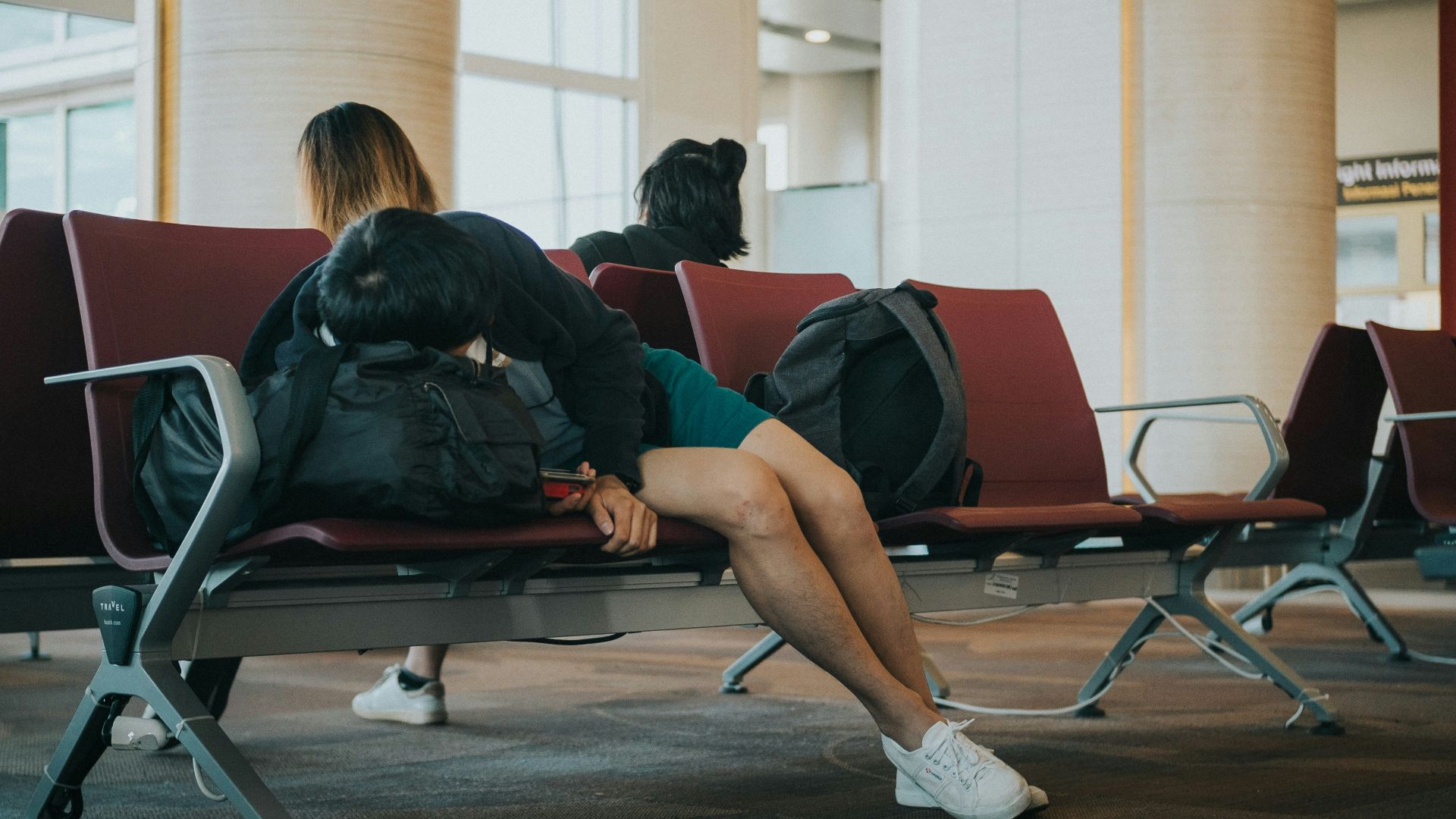 unknown person lying on brown bench indoors