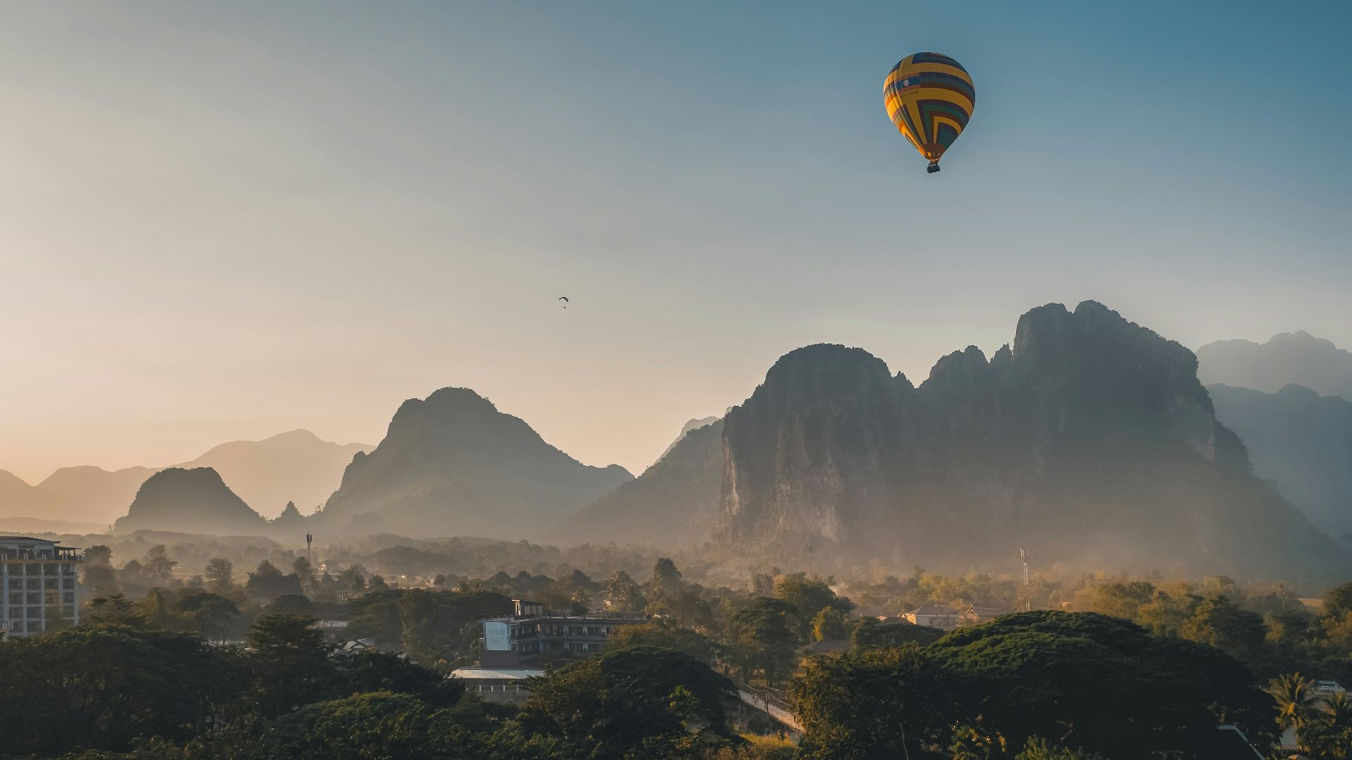 a hot air balloon flying over a mountain range