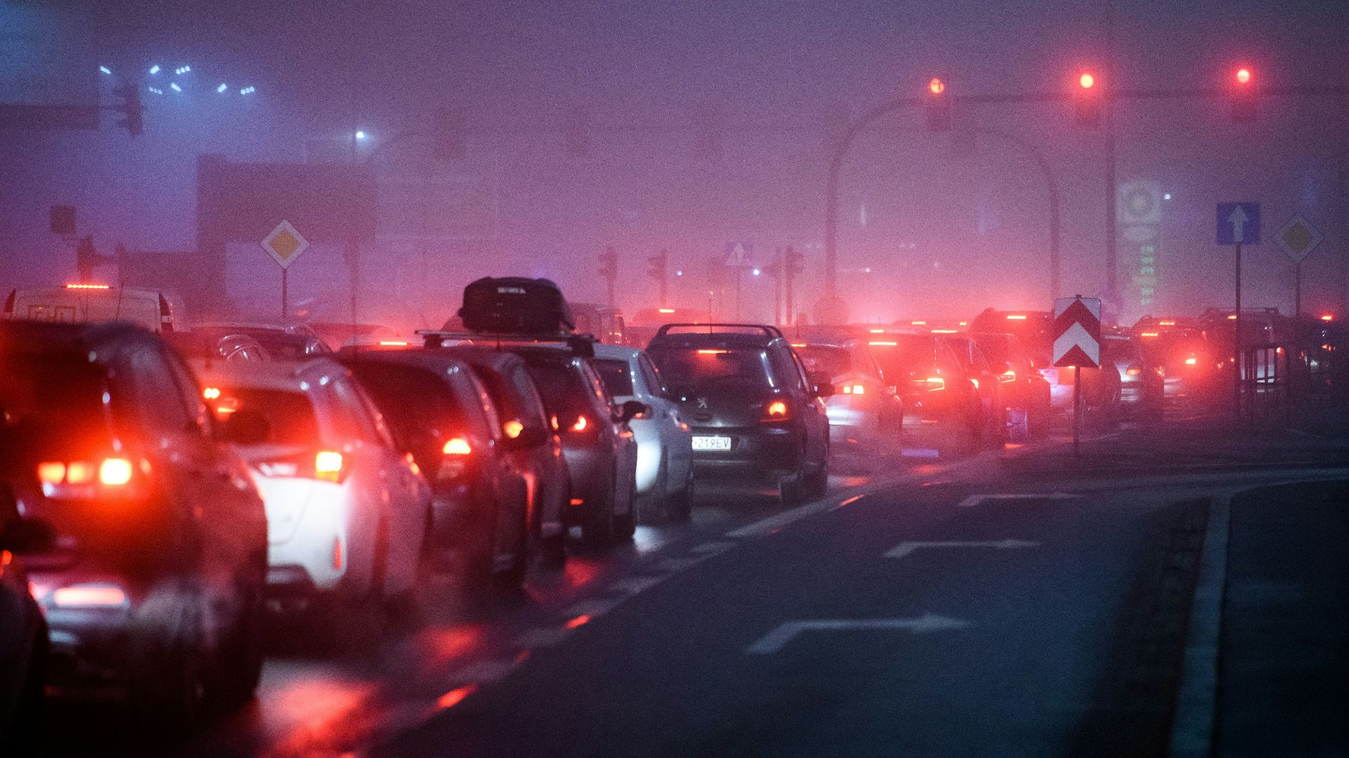 a foggy city street filled with lots of traffic
