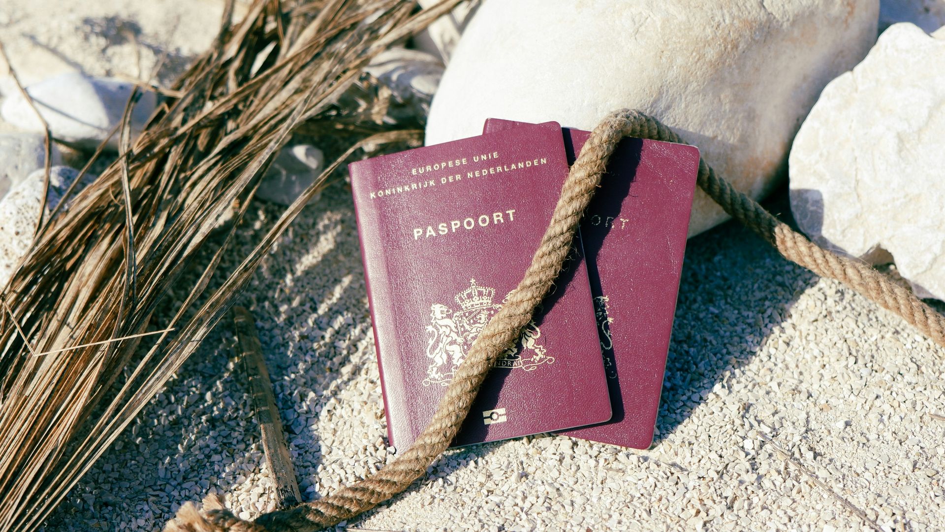 a passport and a rope on the sand