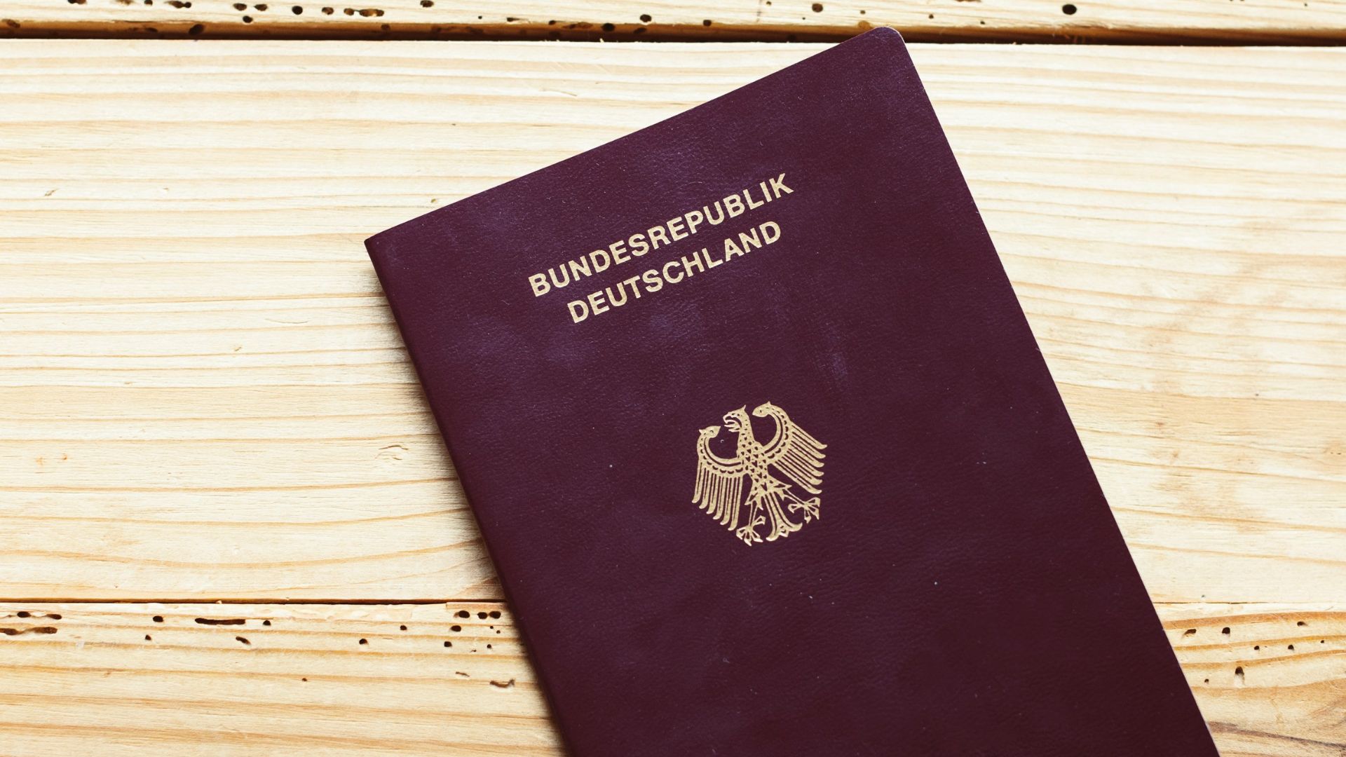 A purple passport sitting on top of a wooden table