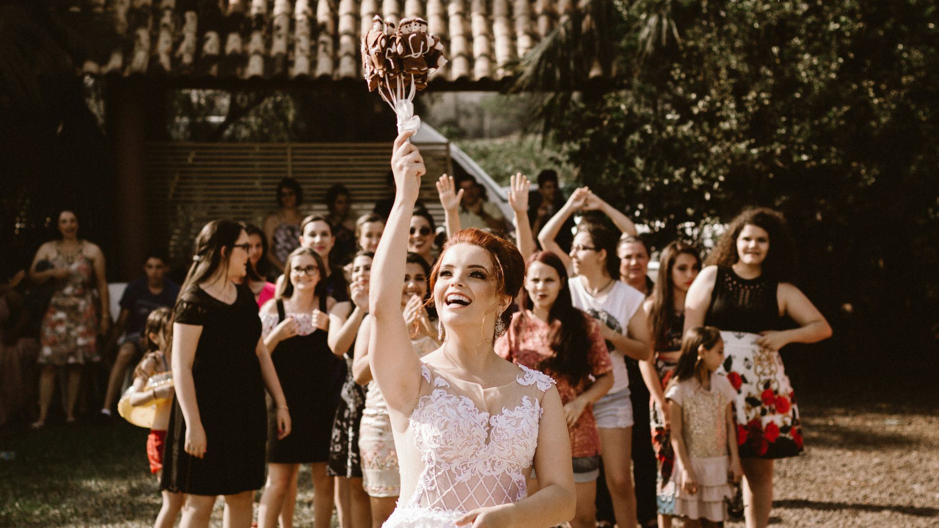 bride throwing flower bouquet on women during daytime