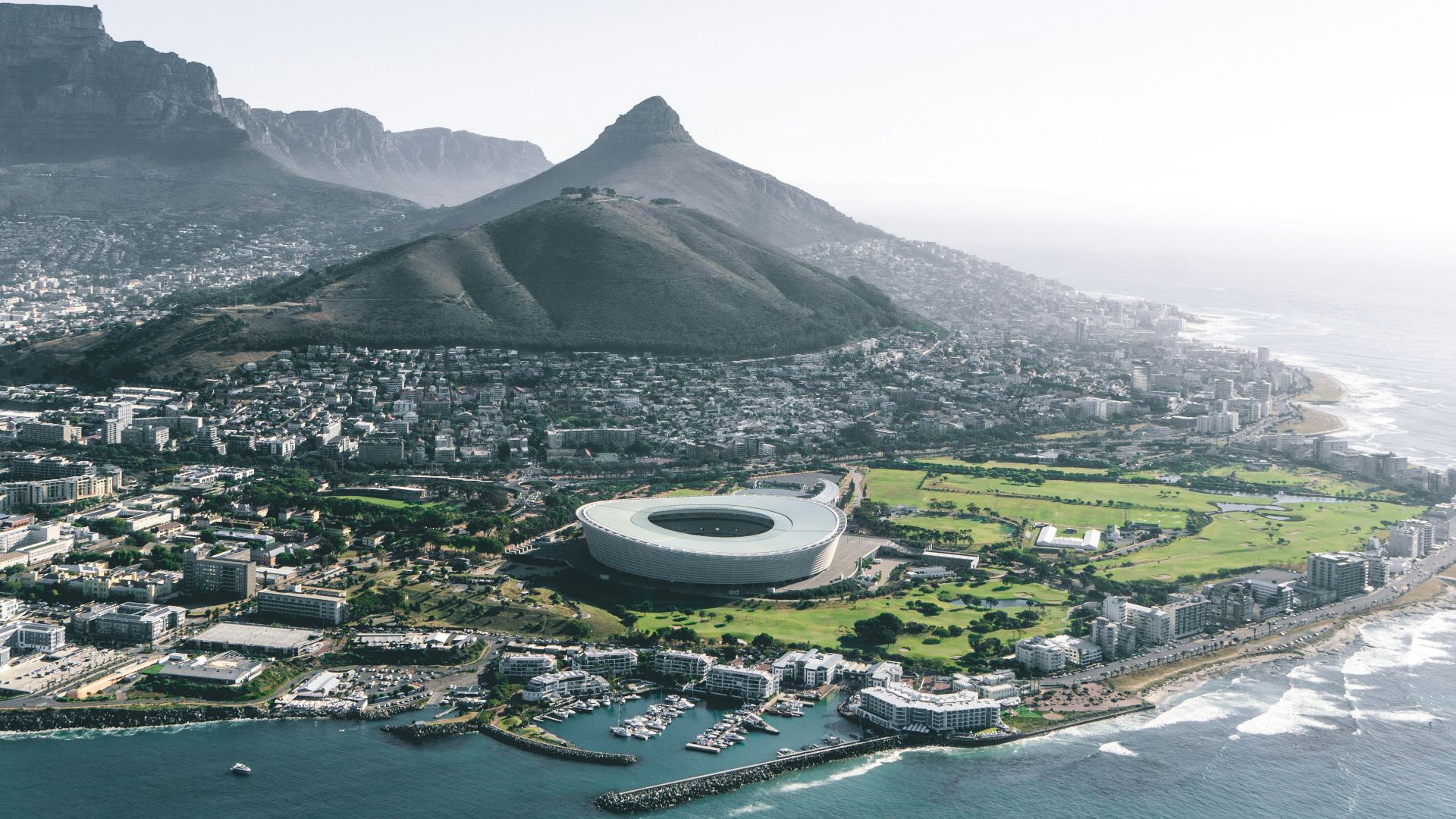 green and white mountain beside body of water during daytime
